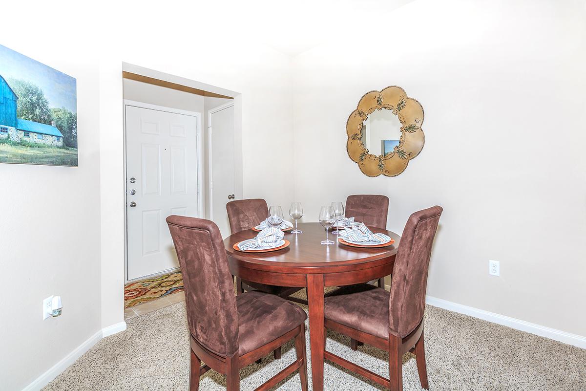 Apartment dining area with four wine glasses and place settings 