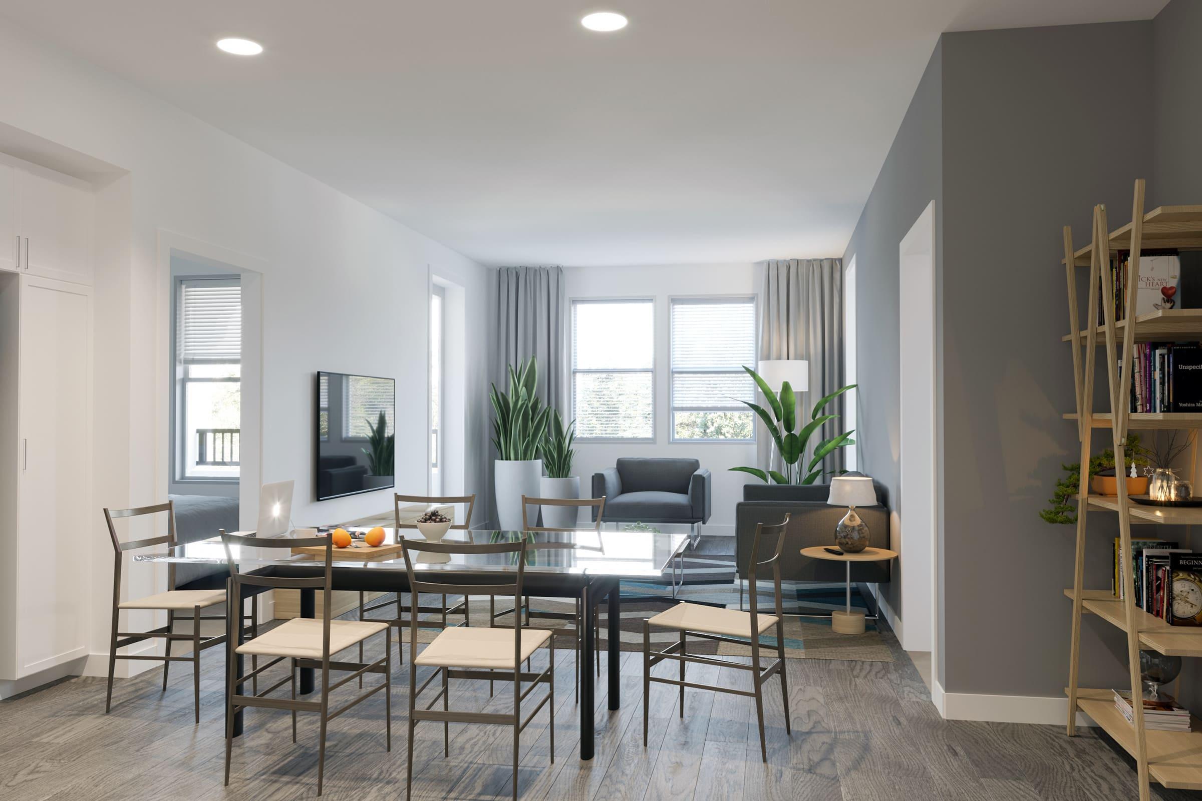 A modern living space featuring a dining area with a glass table and chairs, a cozy living room with a sofa and greenery, large windows allowing natural light, and a bookshelf with various items. The walls are painted in neutral tones, creating a bright and inviting atmosphere.