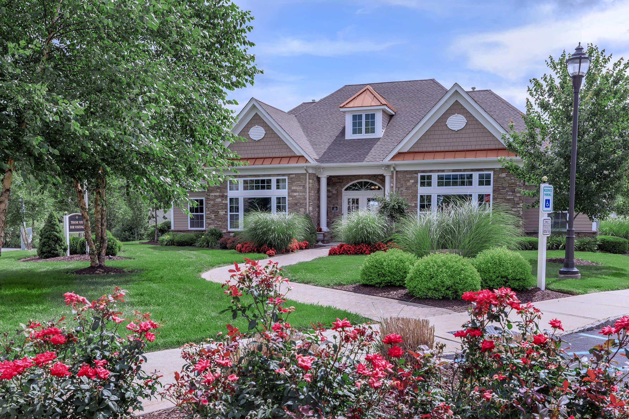 a close up of a flower garden in front of a house