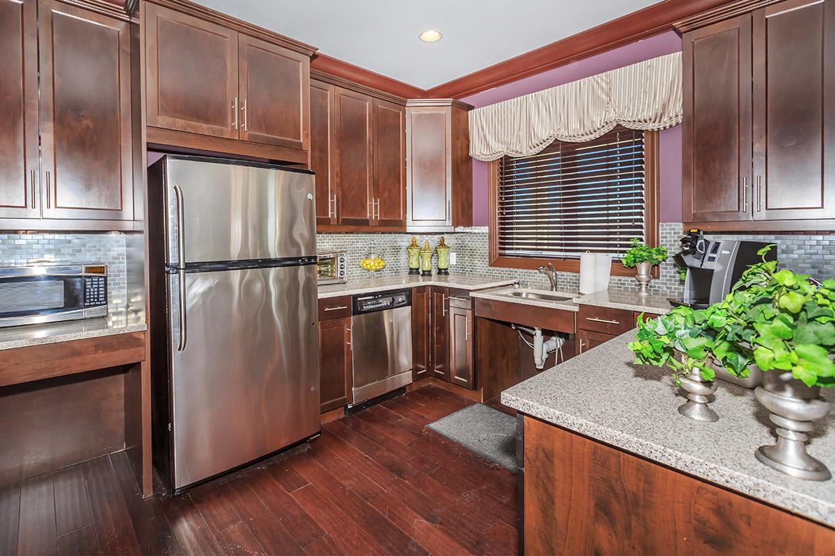 a modern kitchen with stainless steel appliances and wooden cabinets