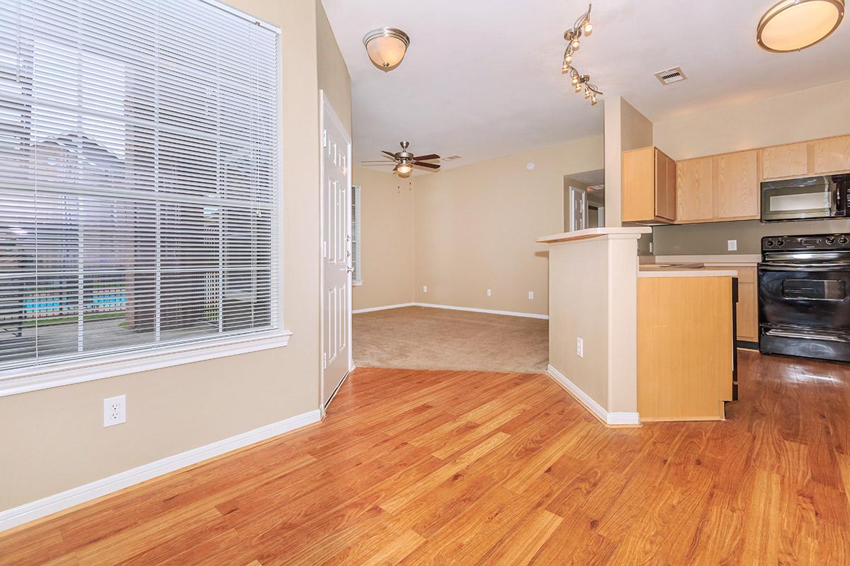 a kitchen with hard wood floors and a large window