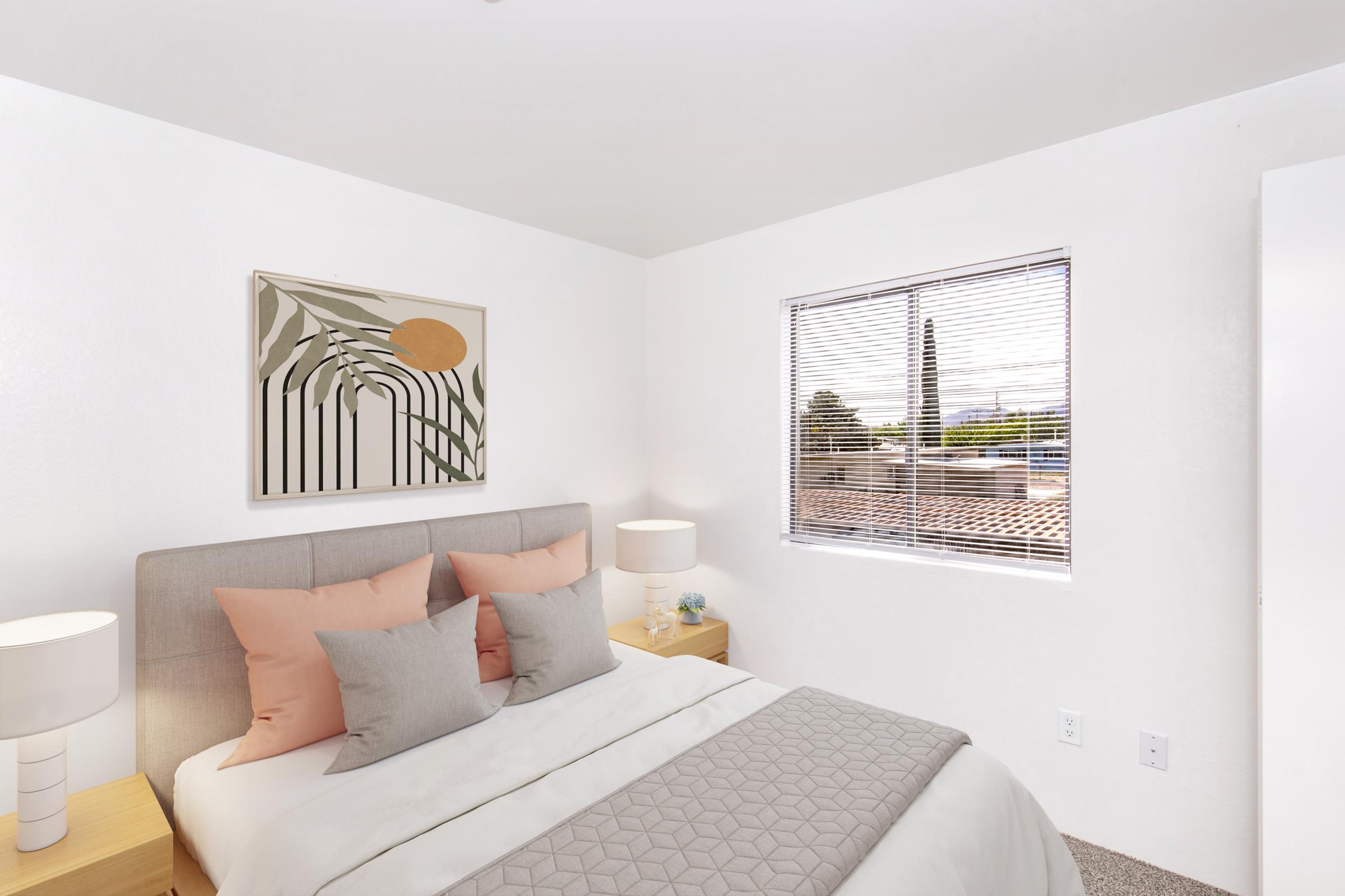 A cozy bedroom featuring a light-colored wall, a large window with blinds, and a neatly made bed dressed in pastel linens. Two bedside tables with lamps complement the decor, while a framed wall art piece adds a touch of style. The overall atmosphere is warm and inviting.