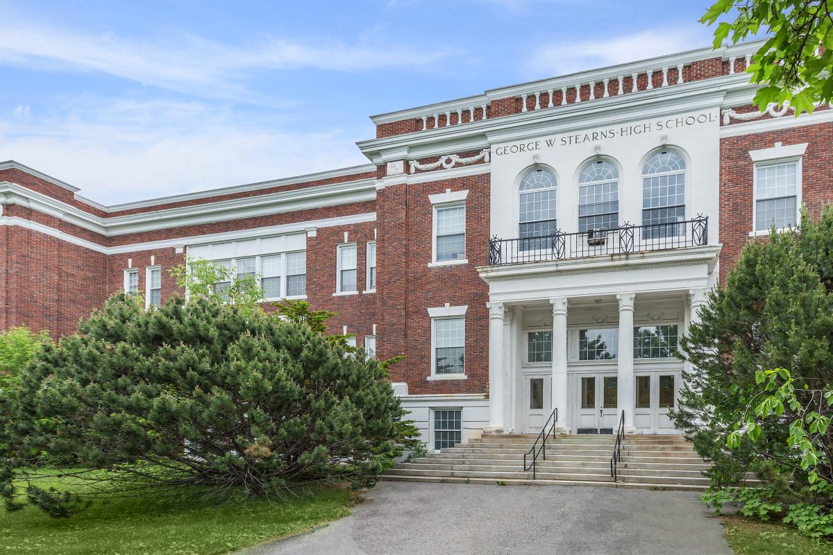 a house with bushes in front of a brick building