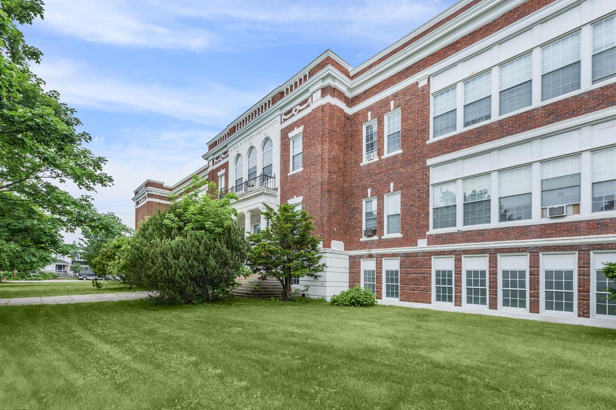 a large lawn in front of a brick building