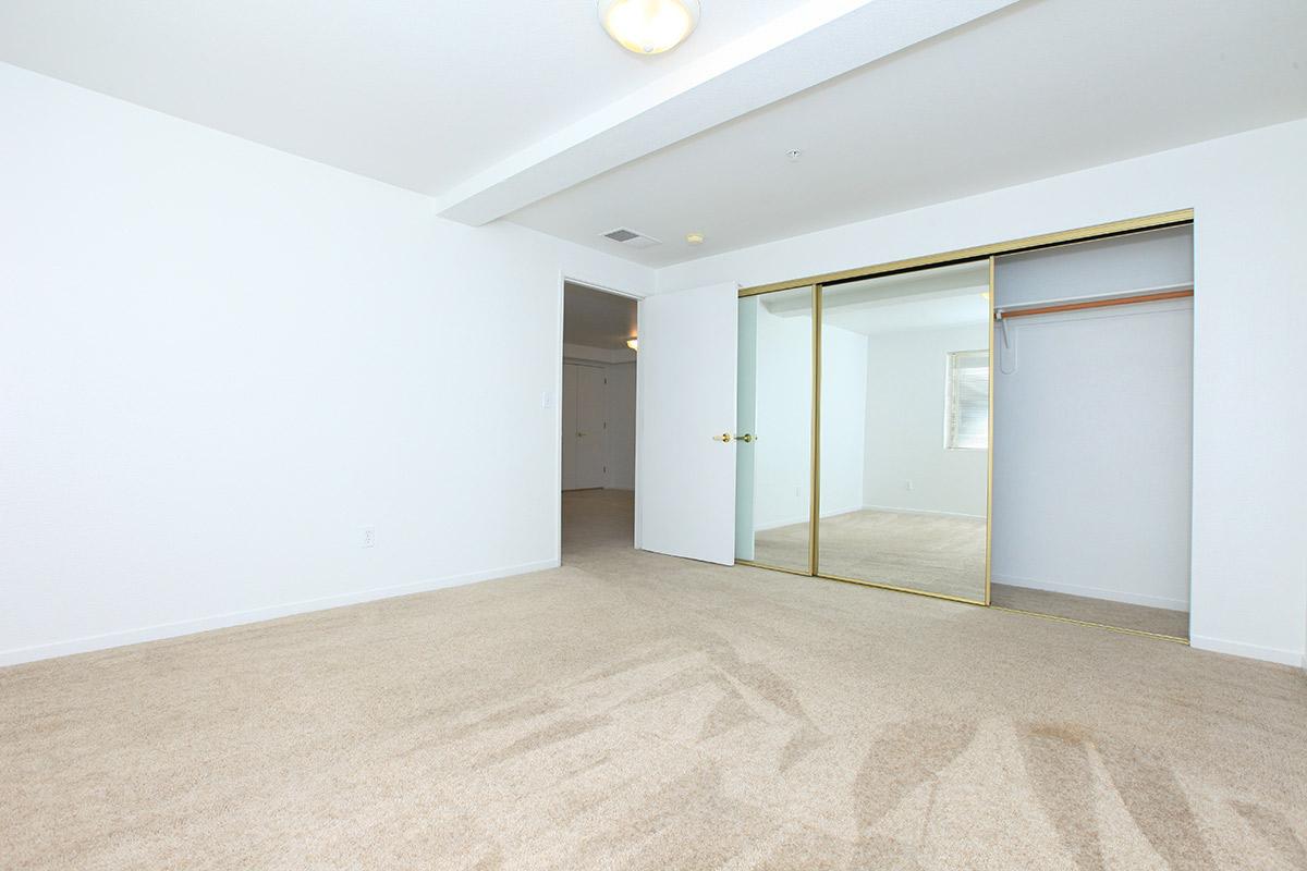 Bedroom with large mirrored closet facing hallway