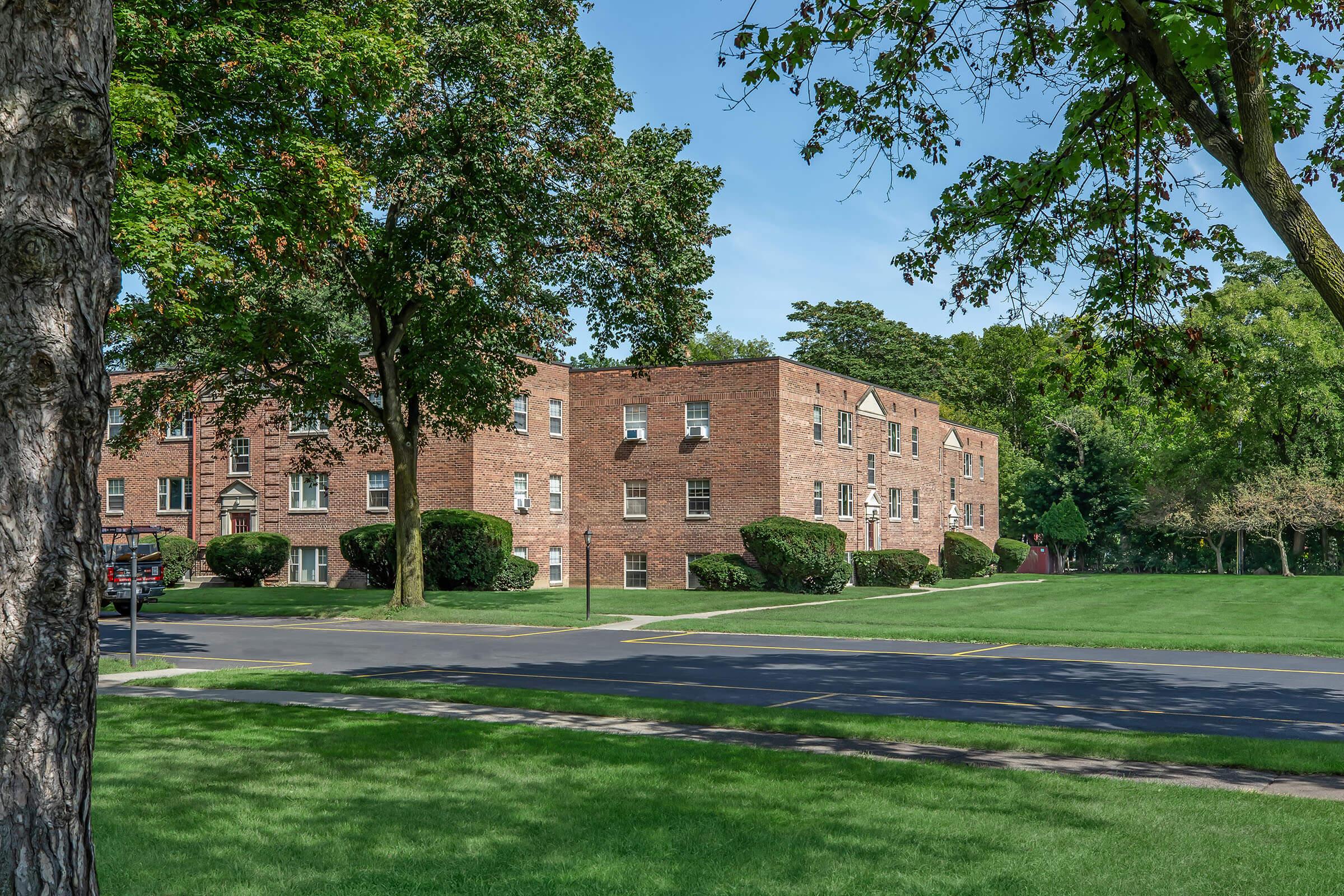 a tree in front of a brick building