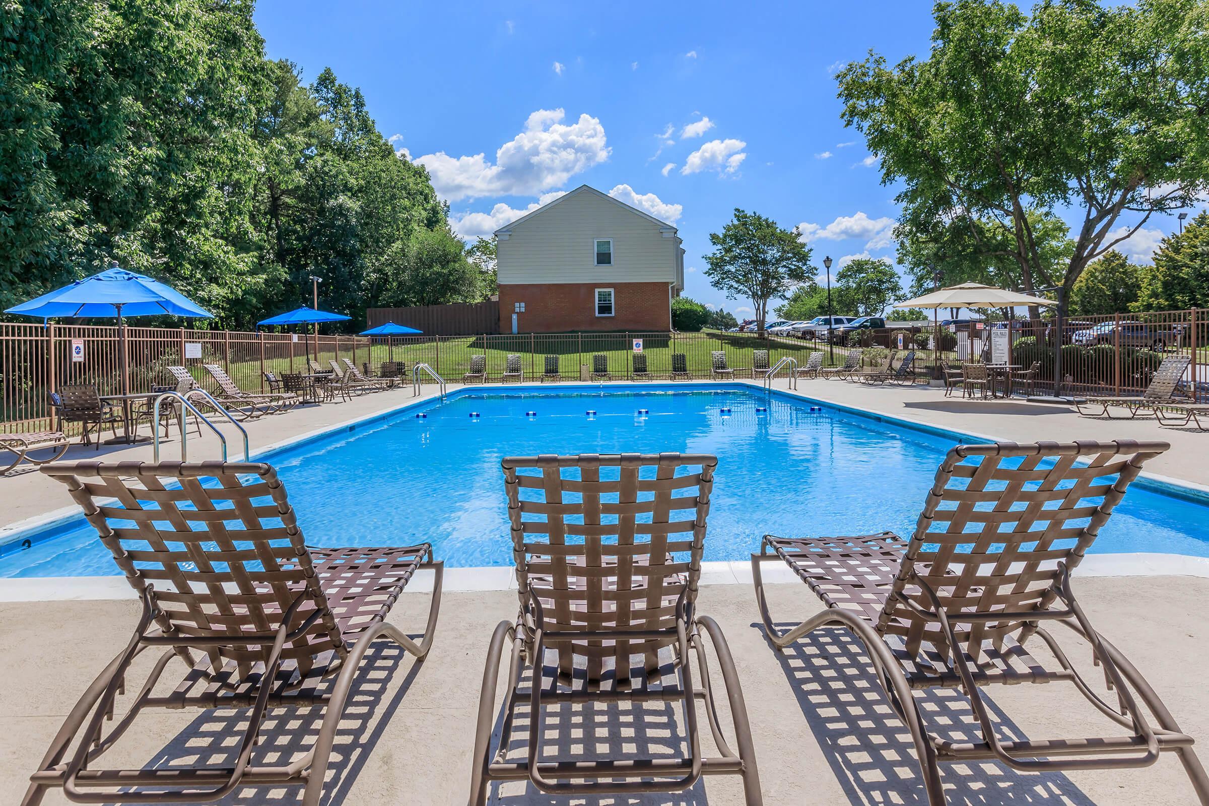 a row of lawn chairs sitting on top of a blue pool