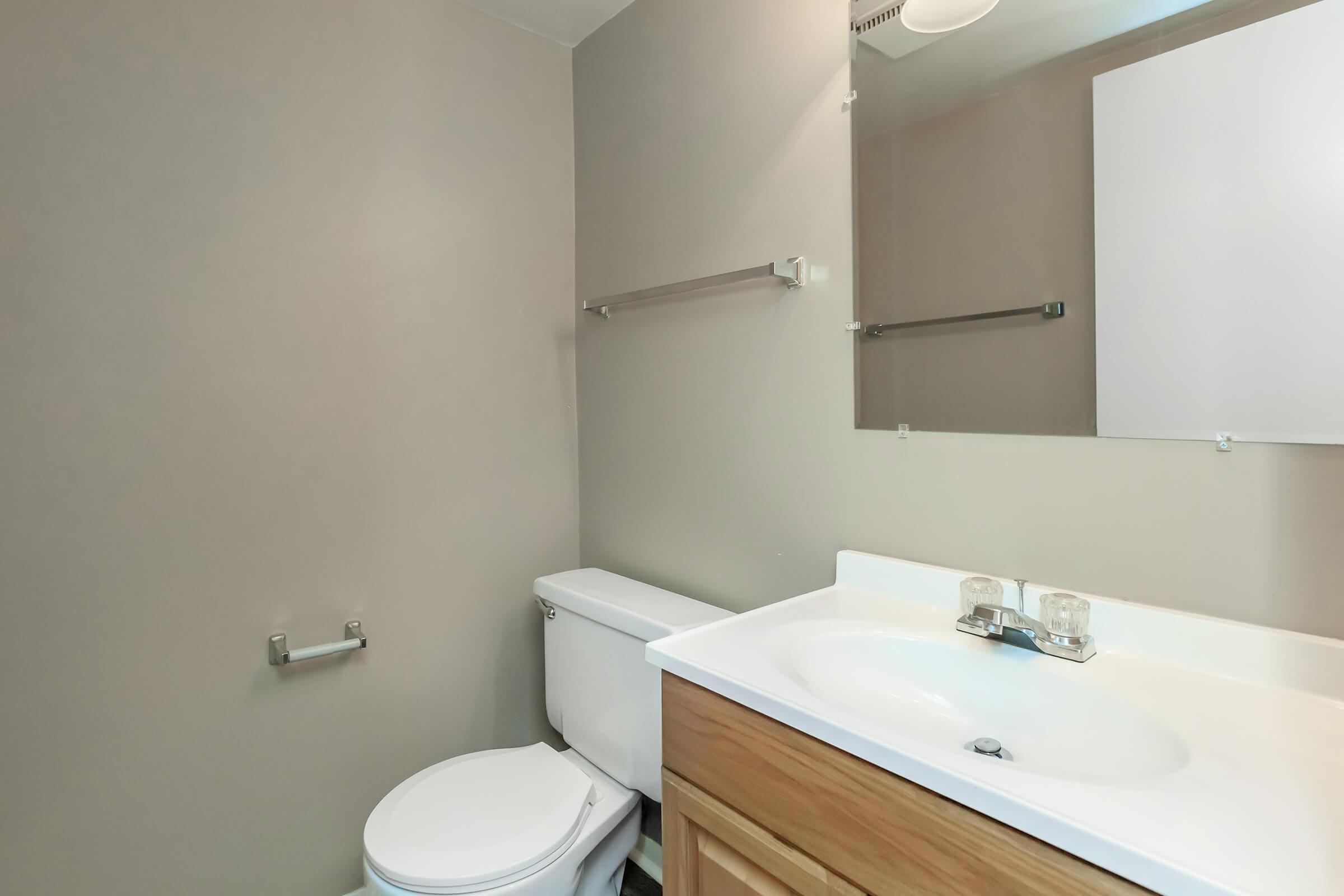 a white sink sitting under a mirror