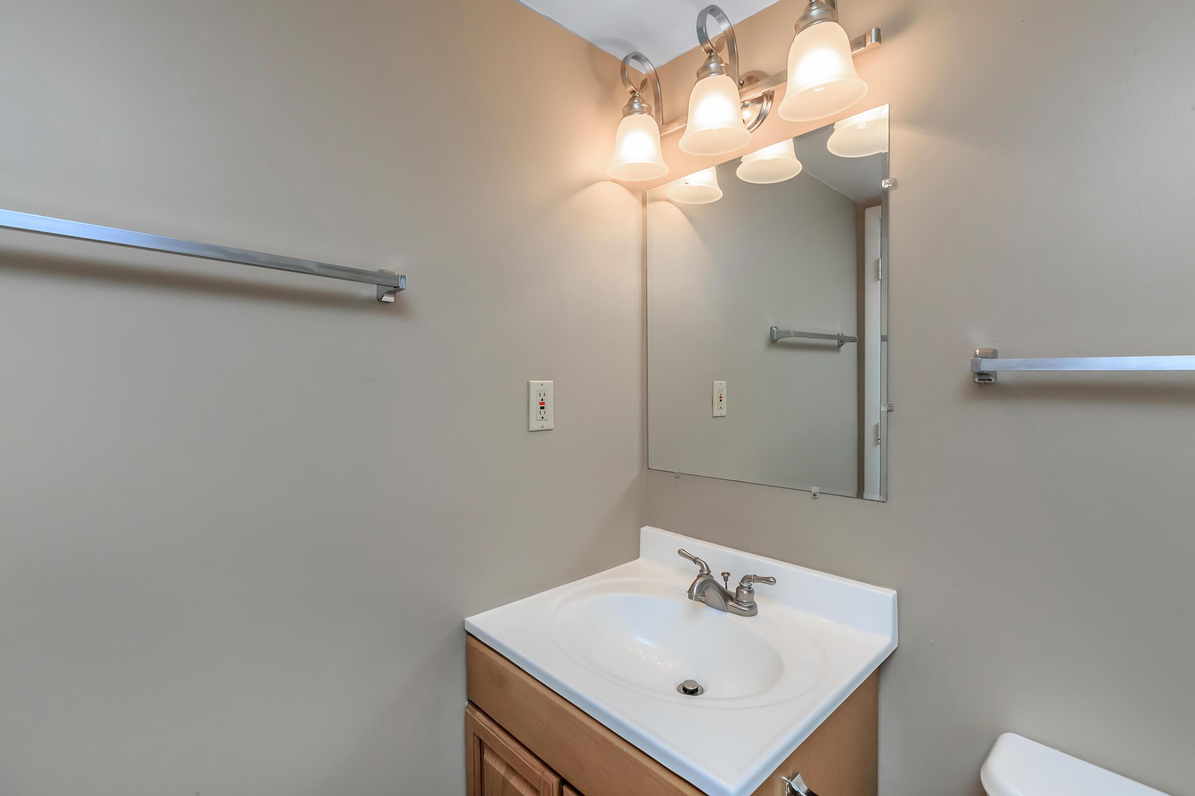 a white sink sitting under a mirror