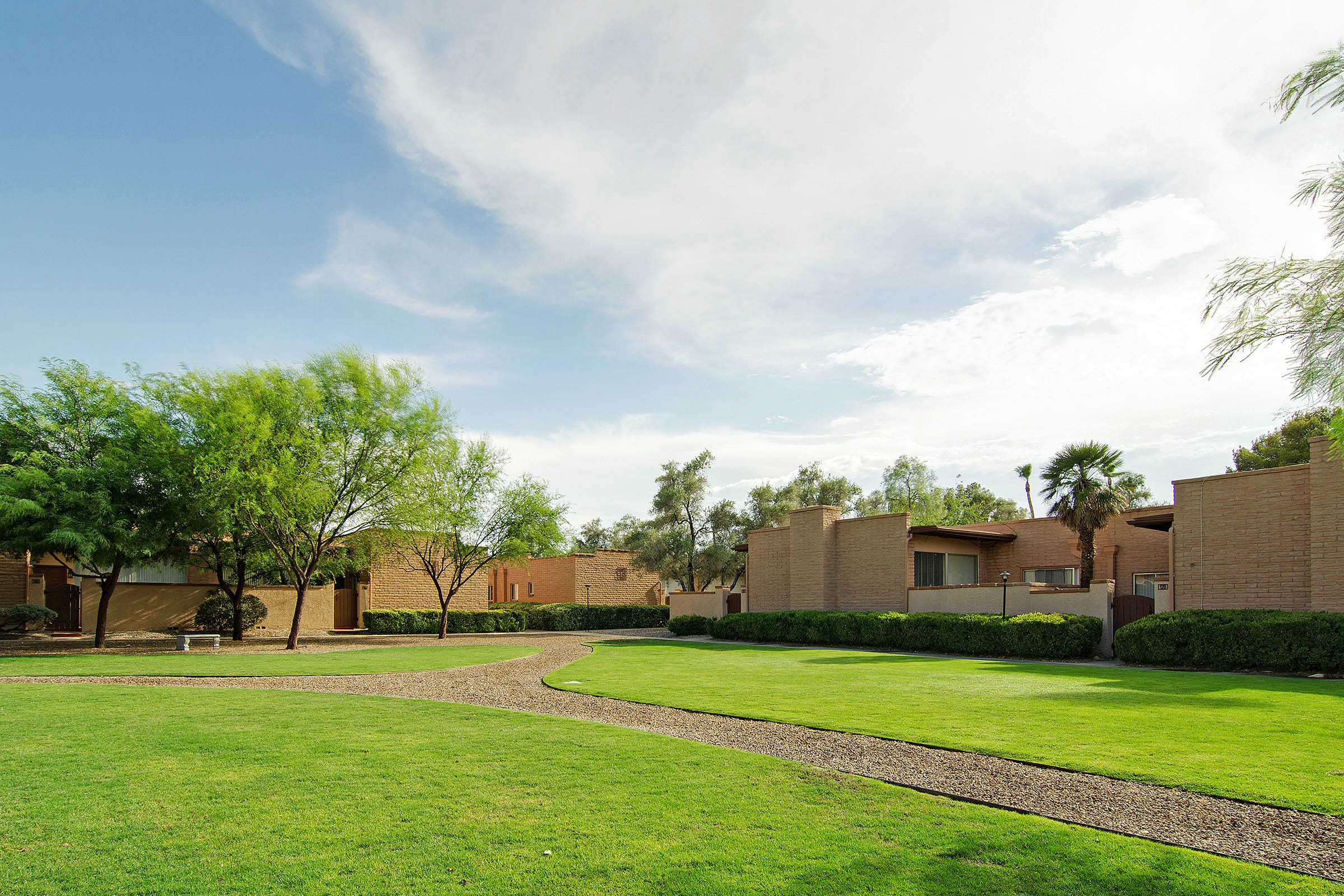 a large brick building with grass in front of a house