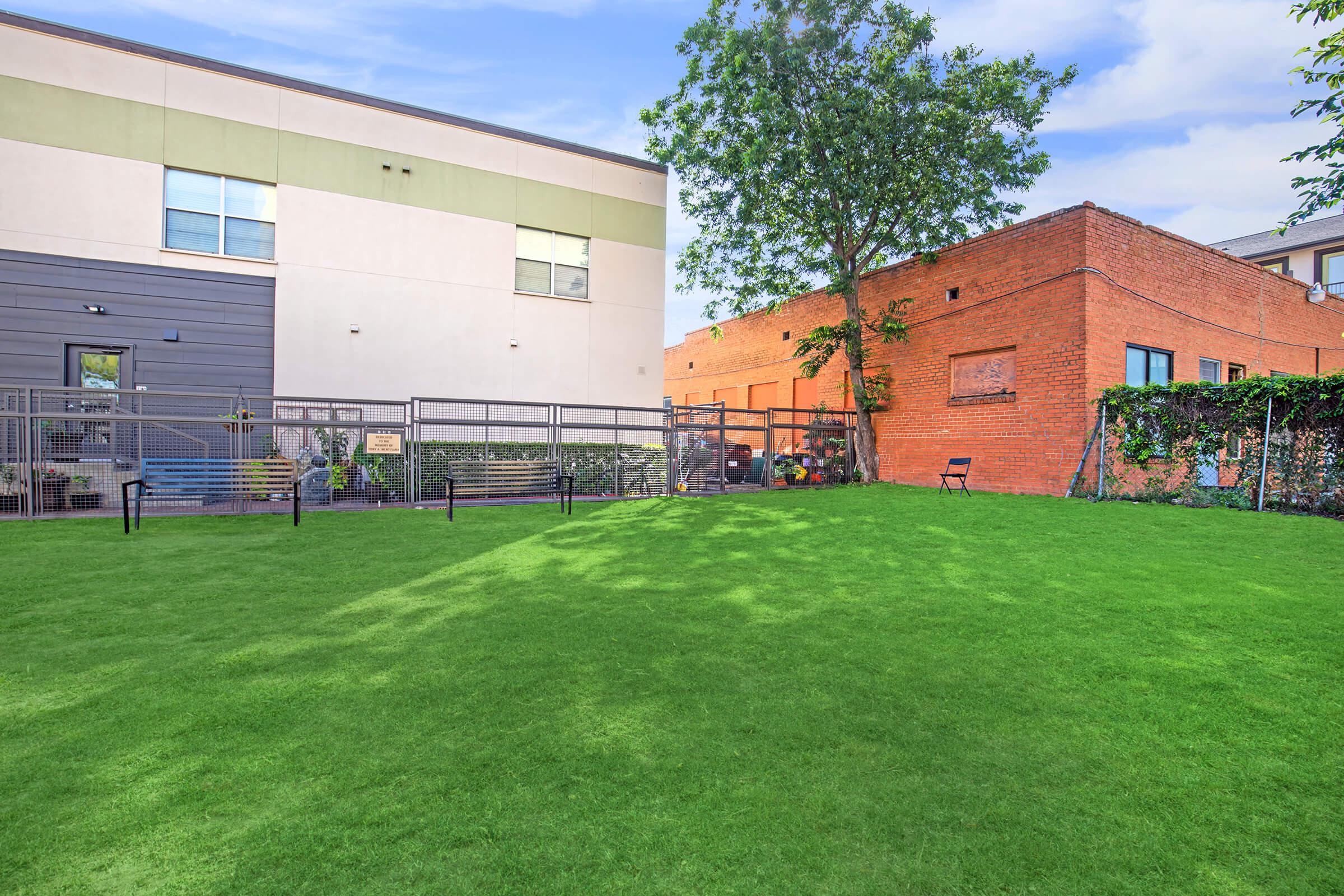 a large brick building with green grass