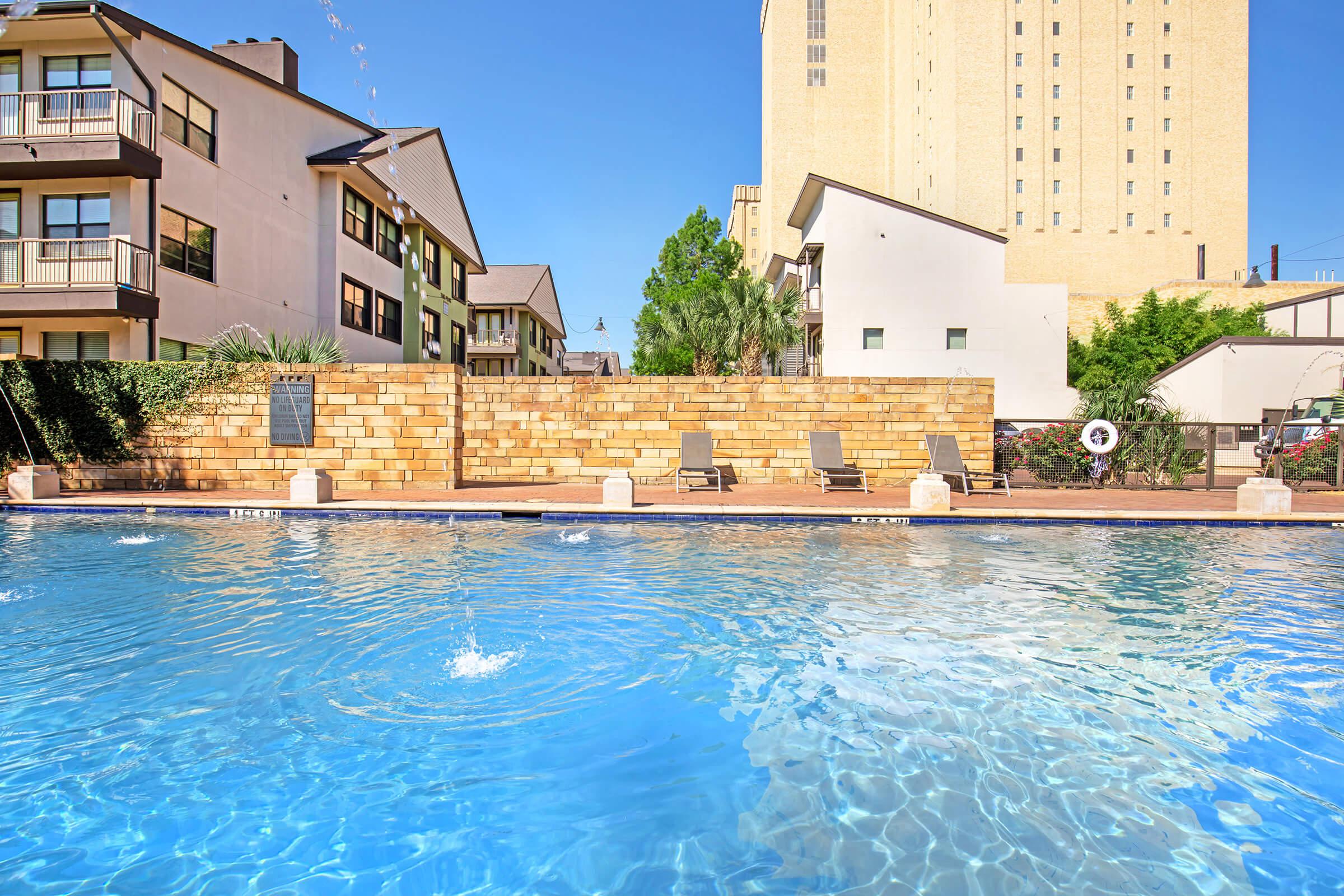 a small clock tower in the middle of a pool of water