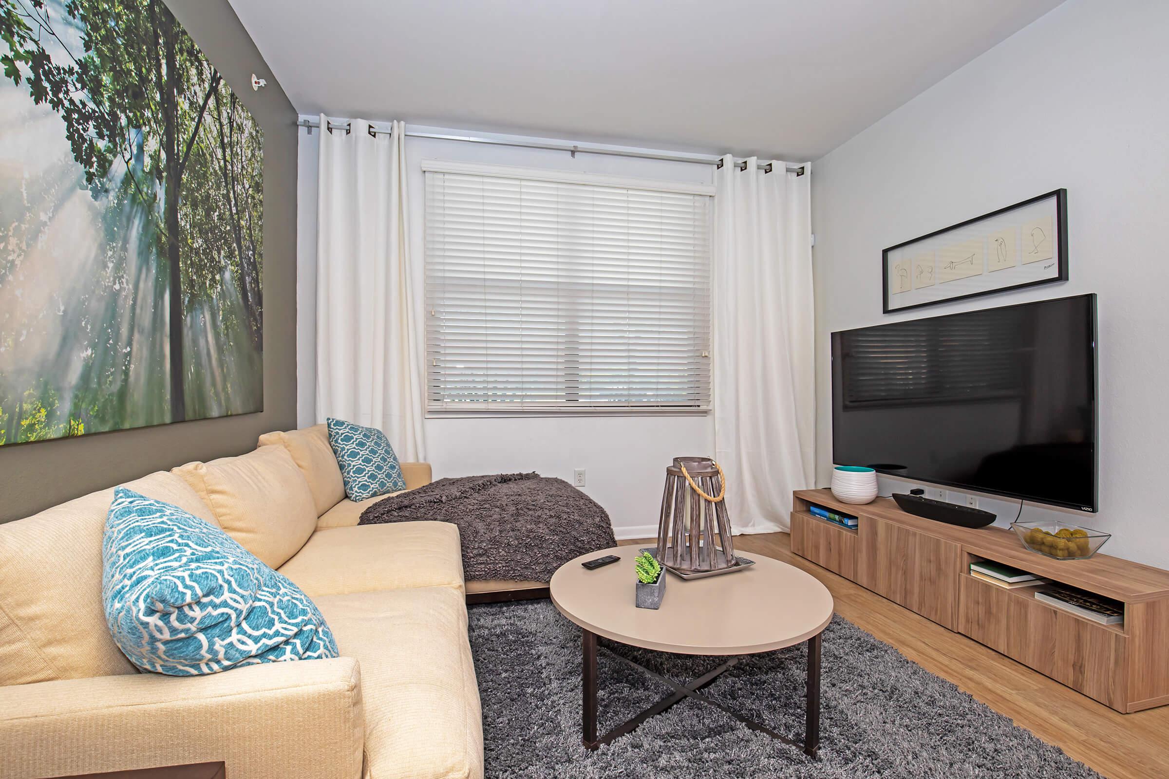 a living room filled with furniture and a large window