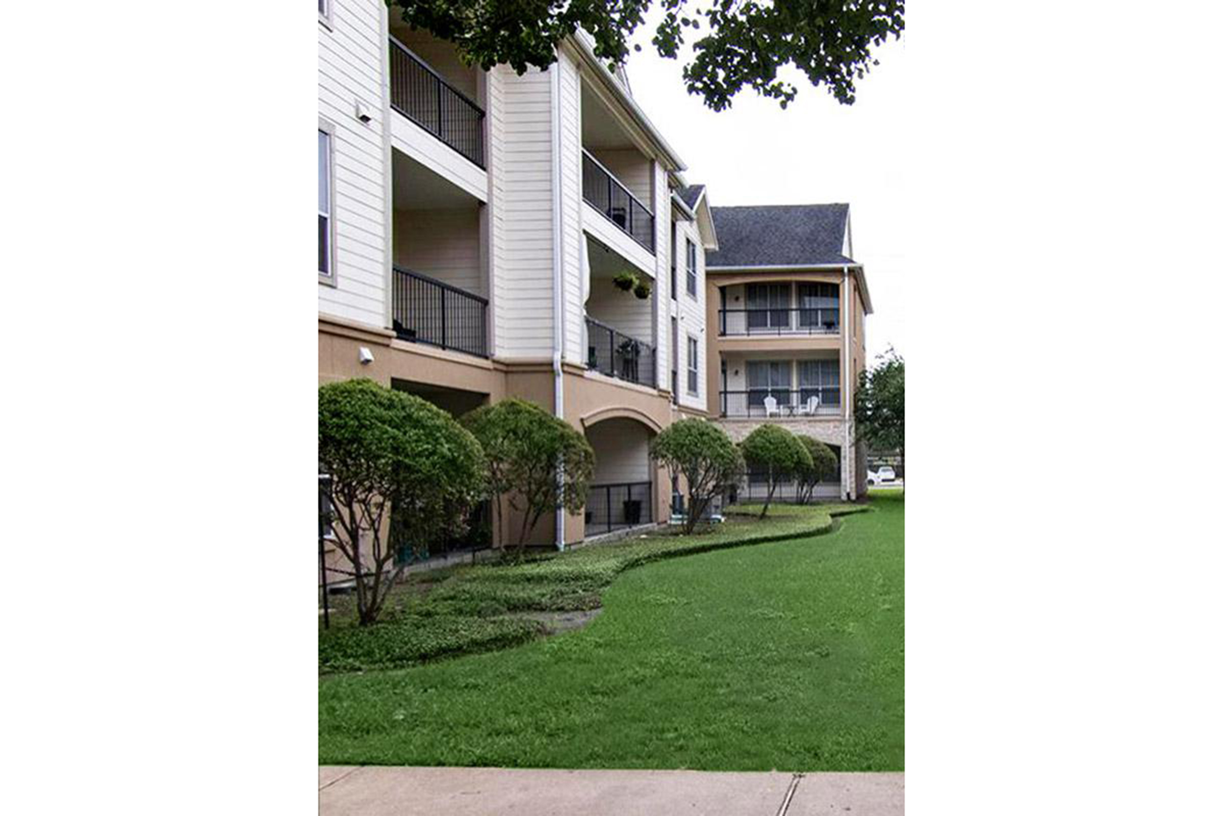 a large brick building with grass in front of a house