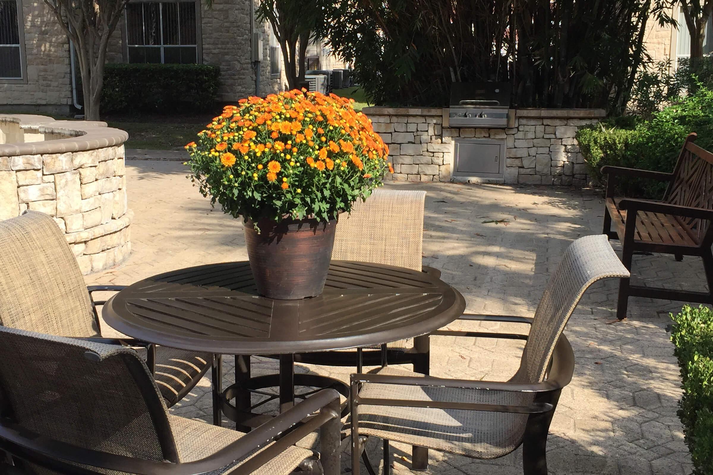 a vase of flowers sitting on a park bench