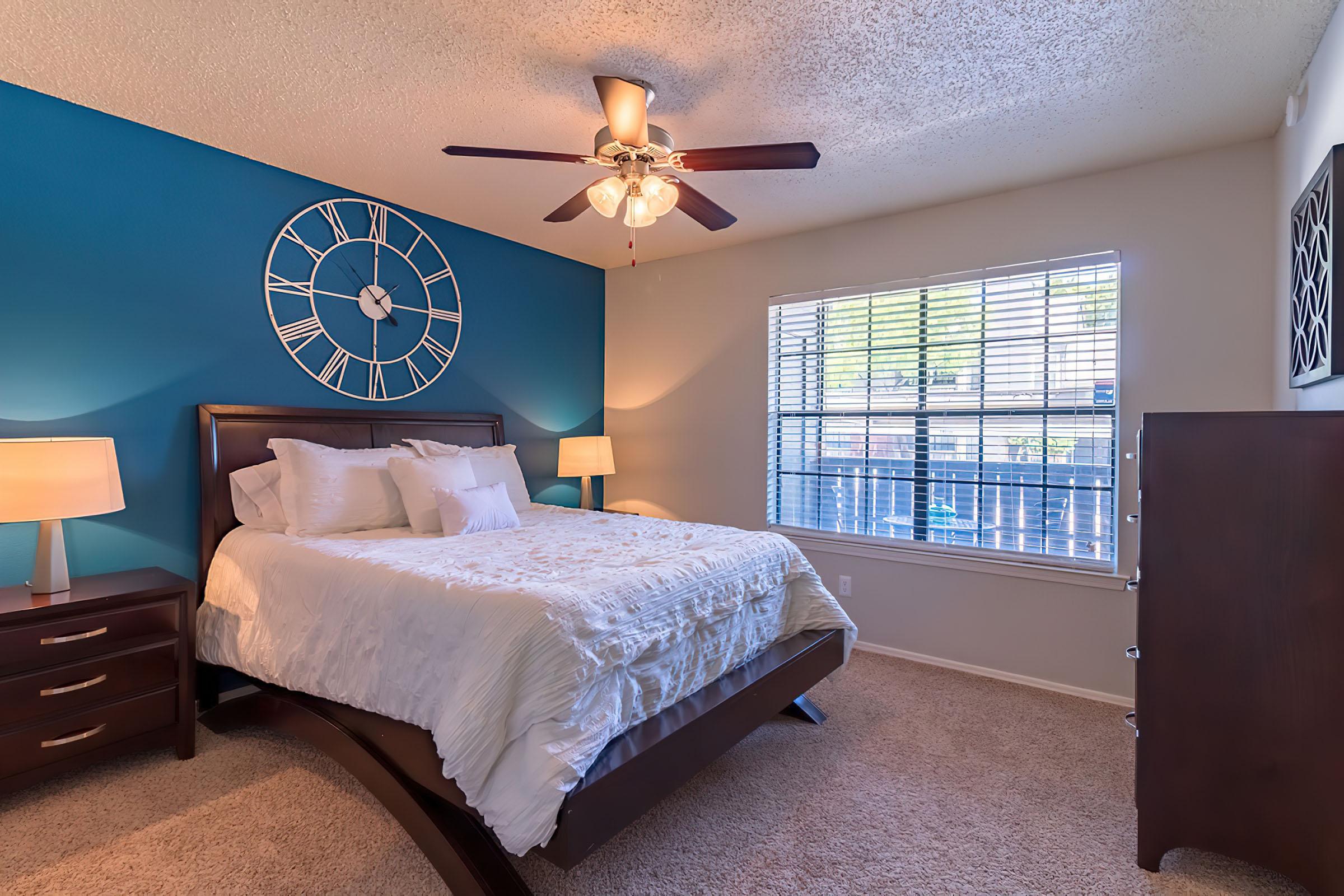 a bedroom with a clock at the top of a bed