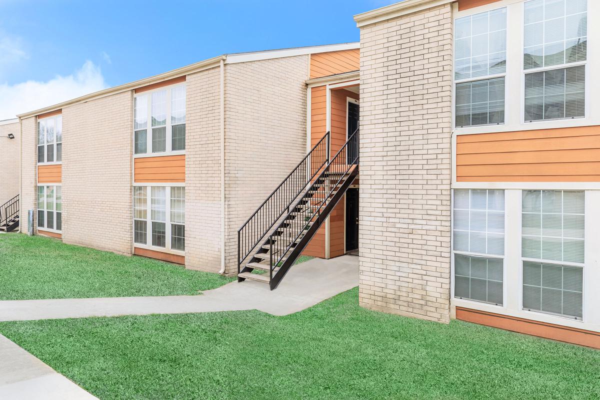 a large lawn in front of a brick building