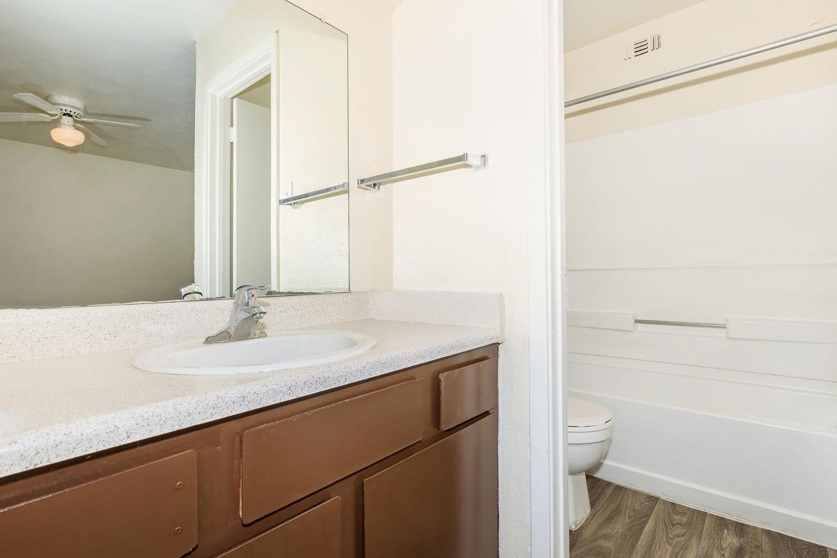 a white sink sitting under a mirror