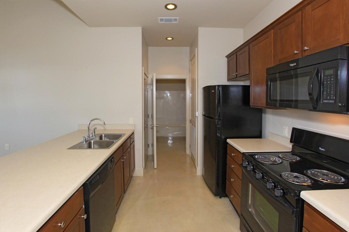 a stove top oven sitting inside of a kitchen with stainless steel appliances