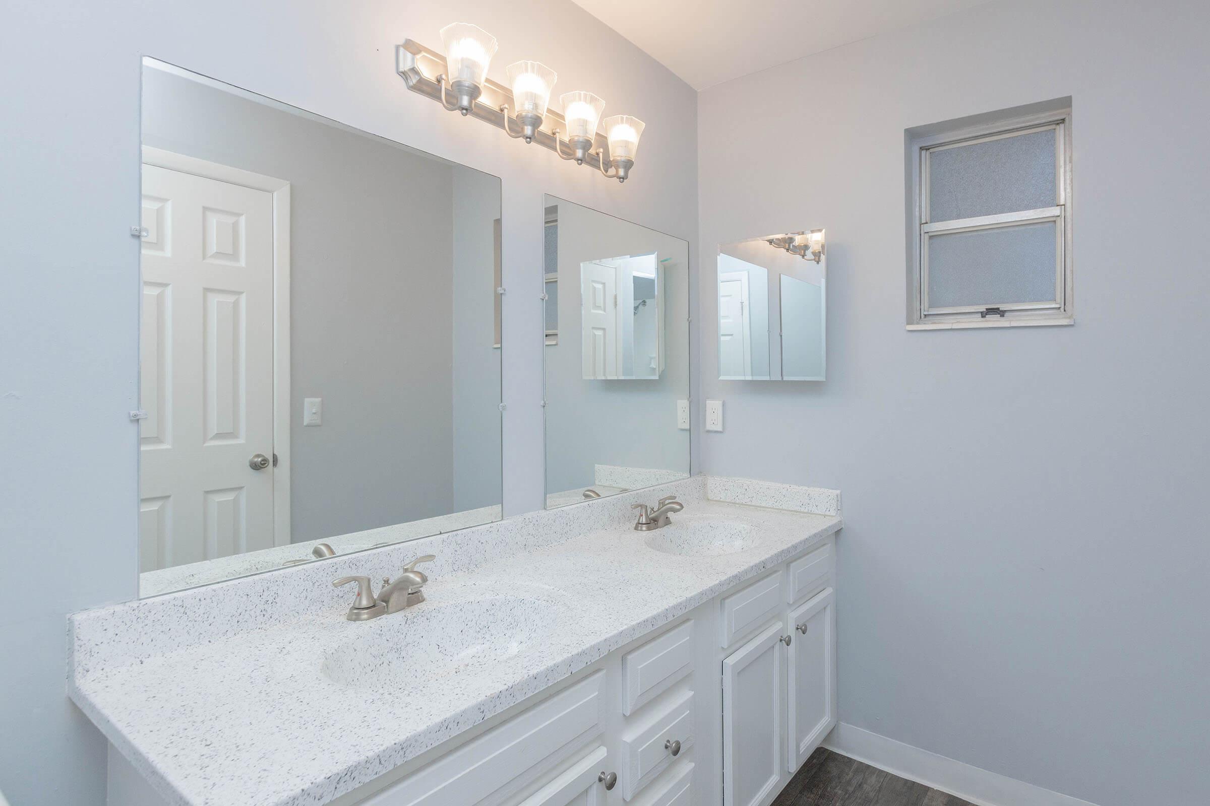 a bedroom area with a sink and a mirror