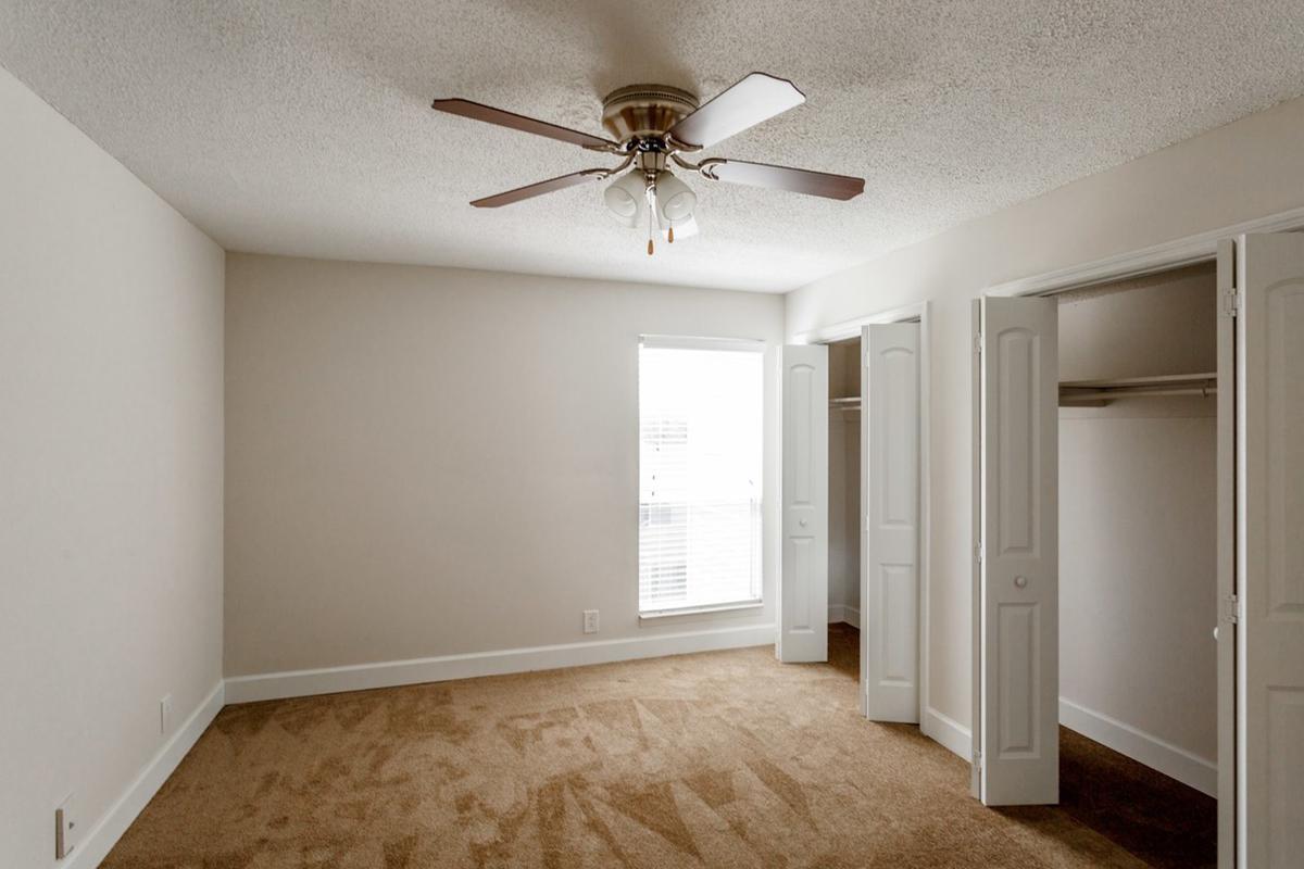 Comfortable bedroom with ceiling fan at Longwood at Southern Hills