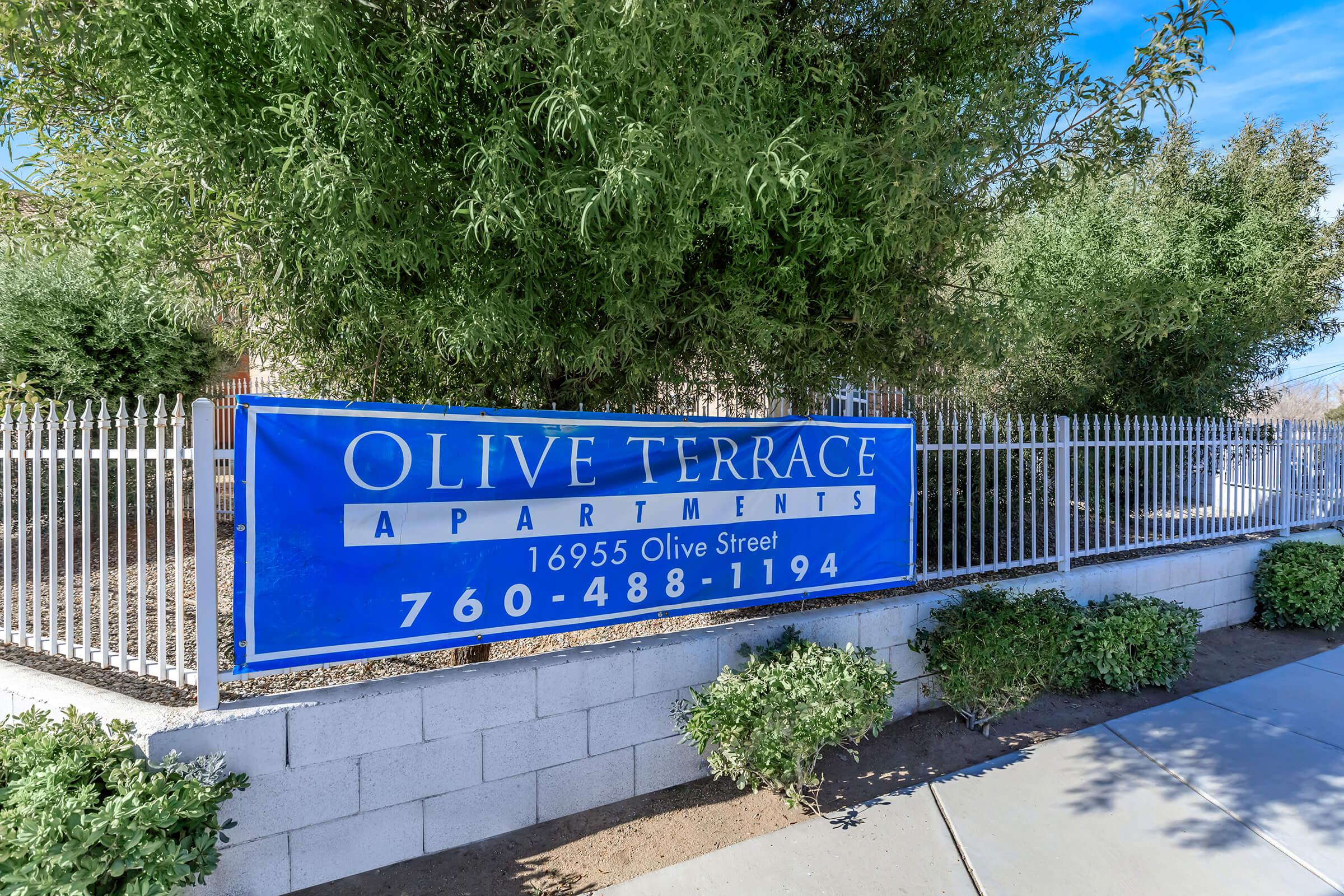 a blue street sign sitting on the side of a fence