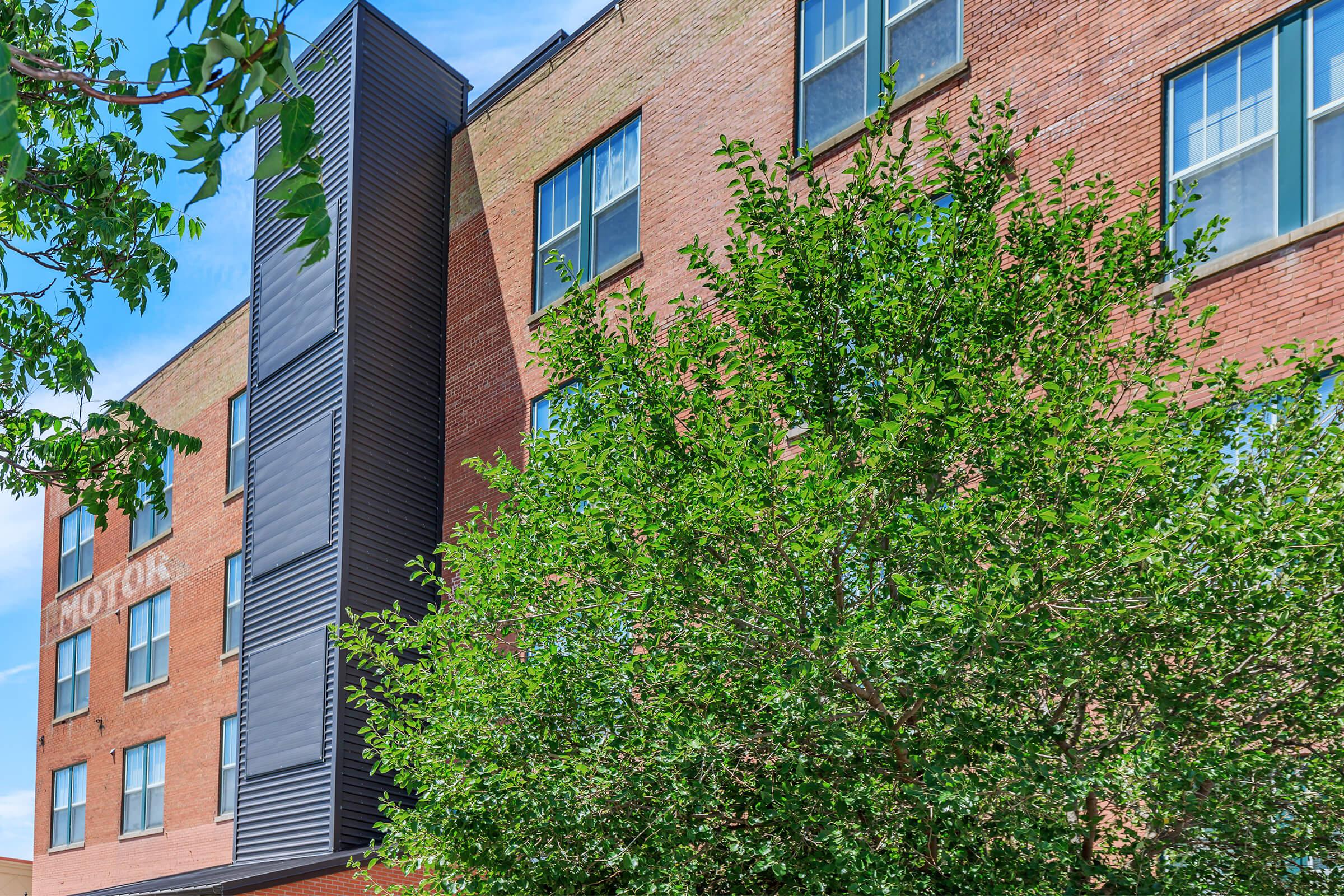 a house with bushes in front of a brick building