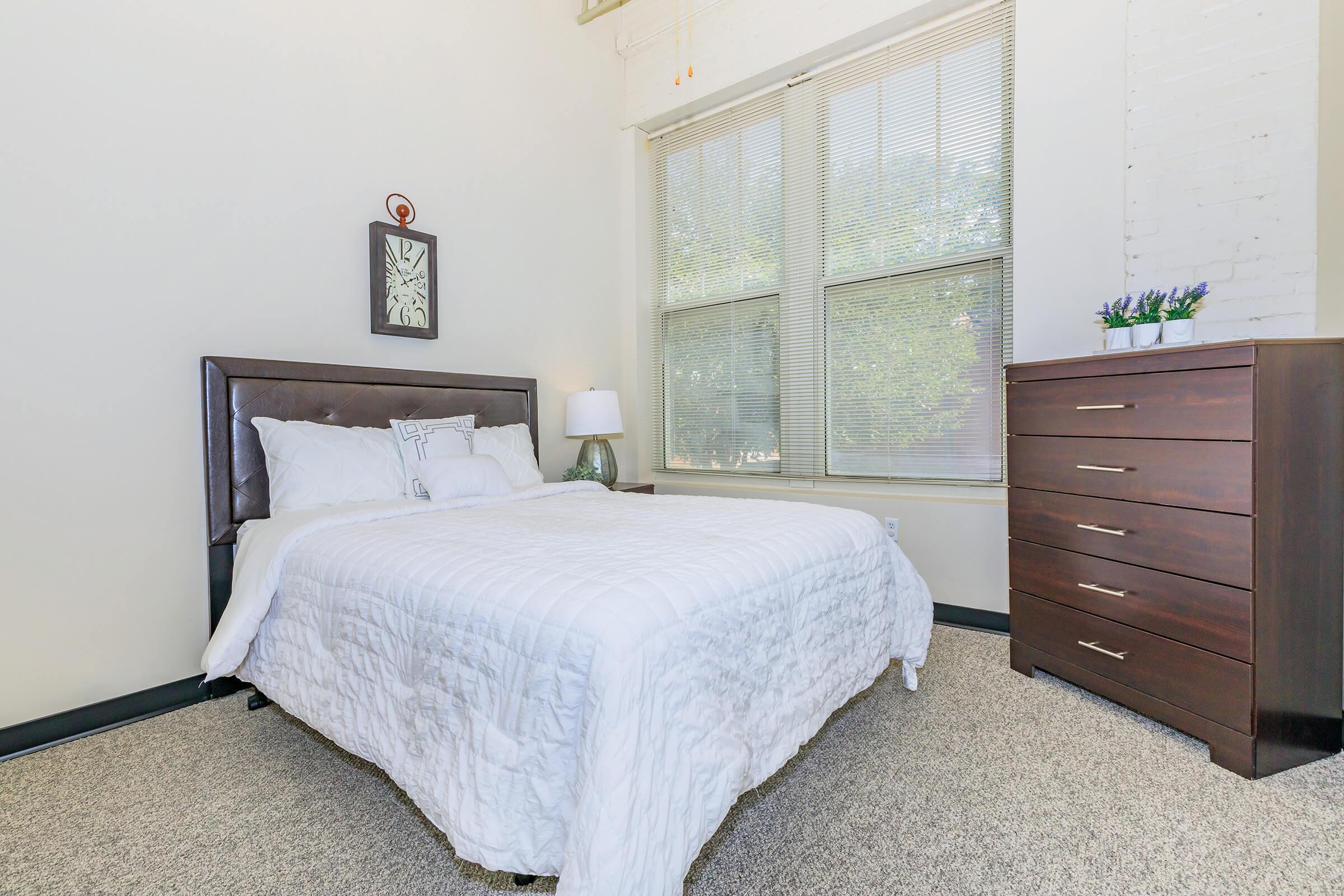 a bedroom with a bed and desk in a small room