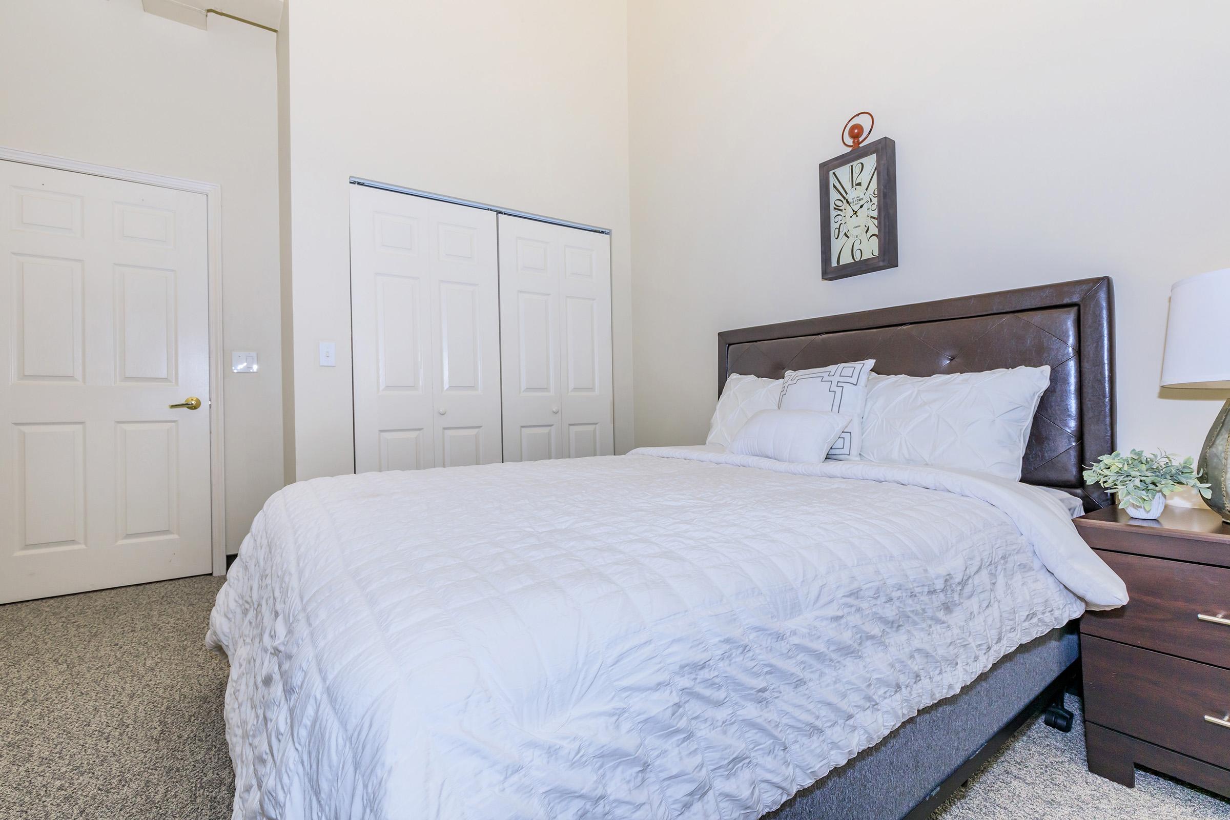 a bedroom with a neatly made bed in a hotel room