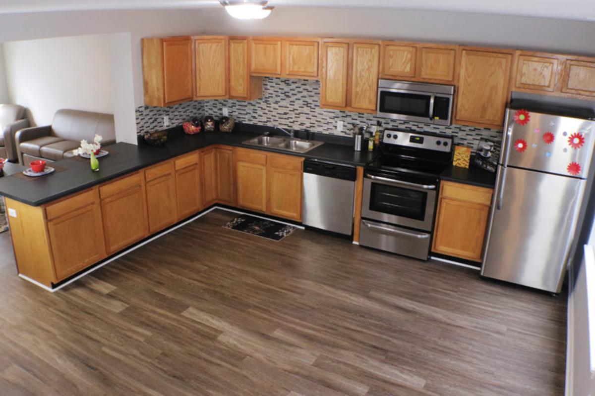 a large kitchen with stainless steel appliances and wooden cabinets