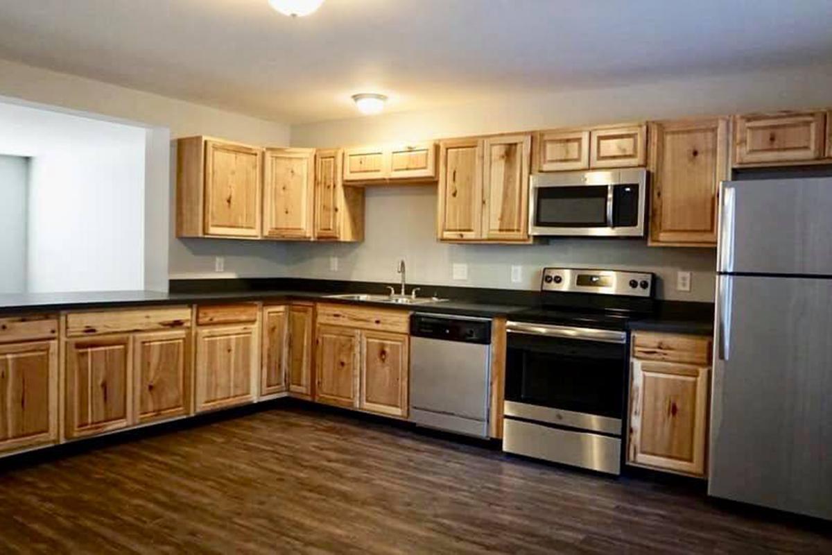 a large kitchen with stainless steel appliances and wooden cabinets