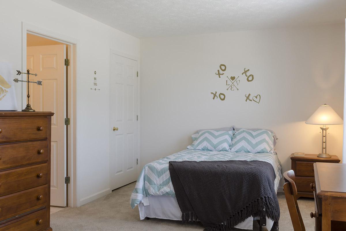 a bedroom with a bed and desk in a small room