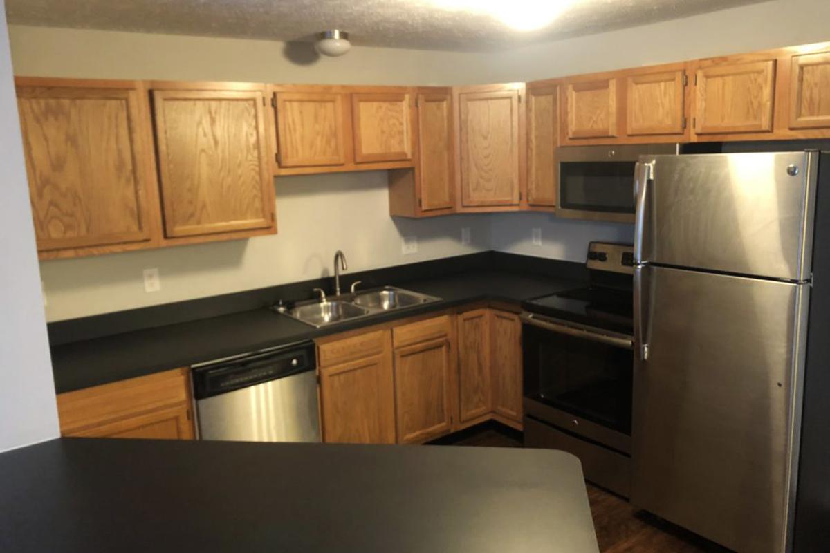 a kitchen with stainless steel appliances and wooden cabinets