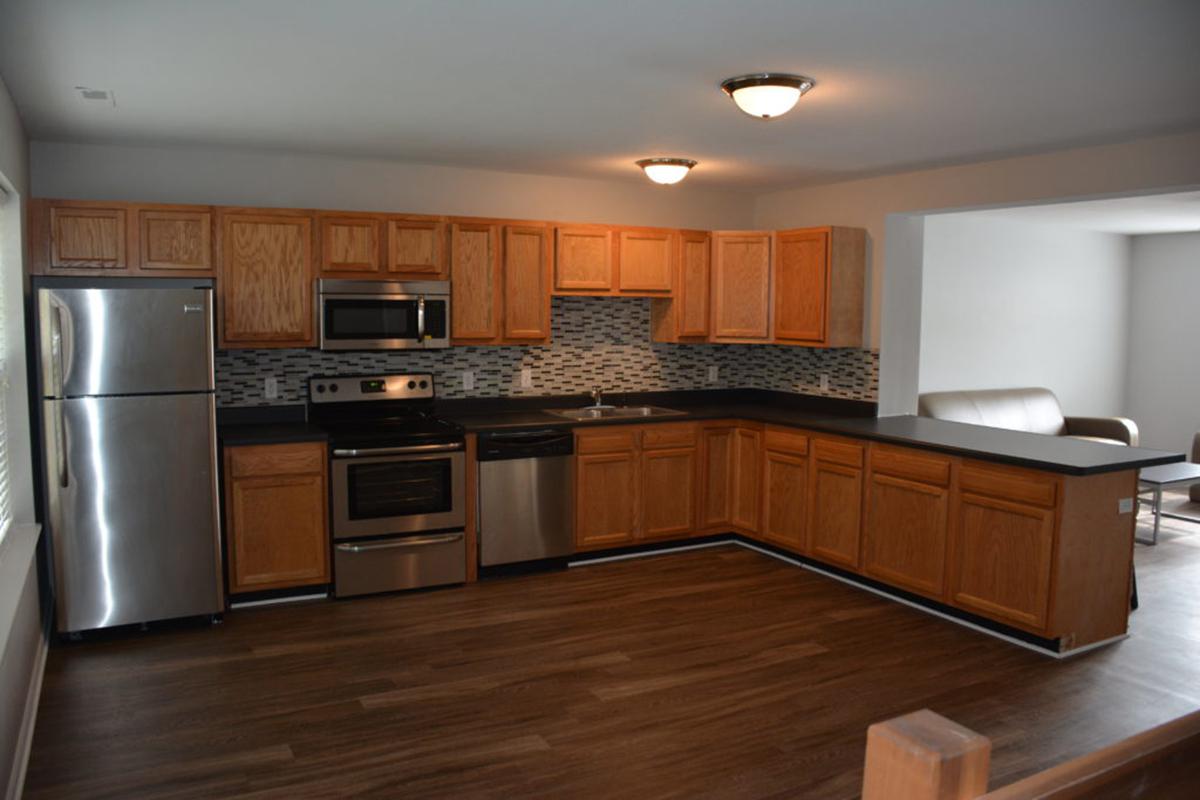 a large kitchen with stainless steel appliances and wooden cabinets