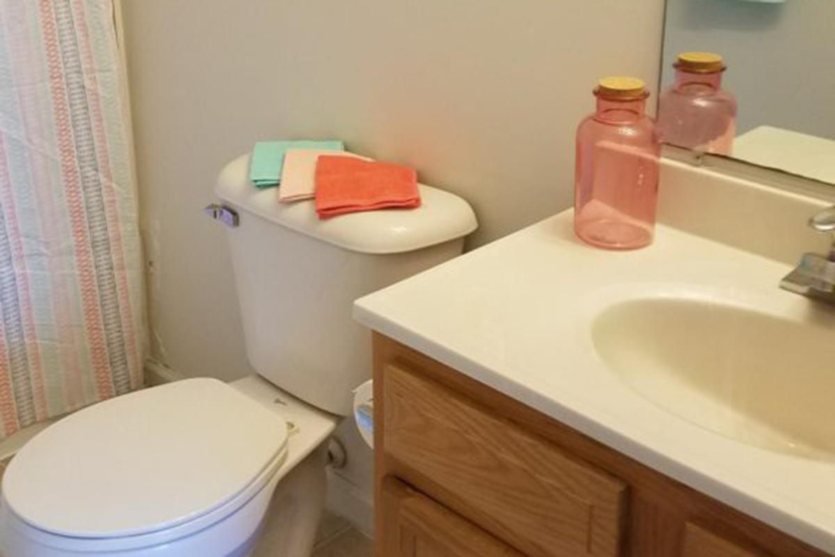 a white sink sitting under a mirror