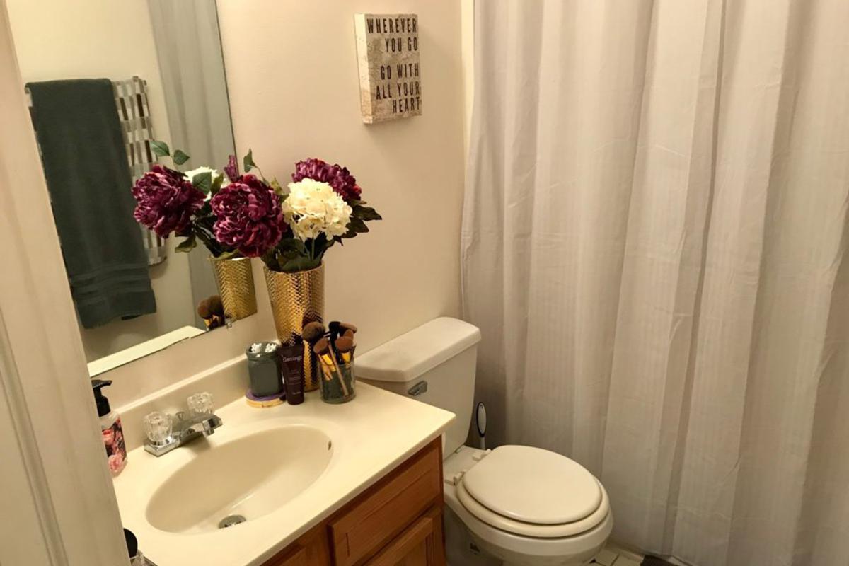 a white sink sitting next to a shower curtain