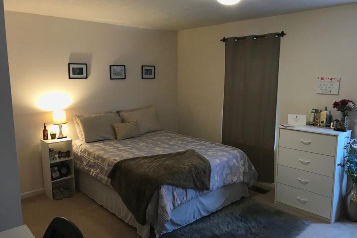 a bedroom with a bed and desk in a small room