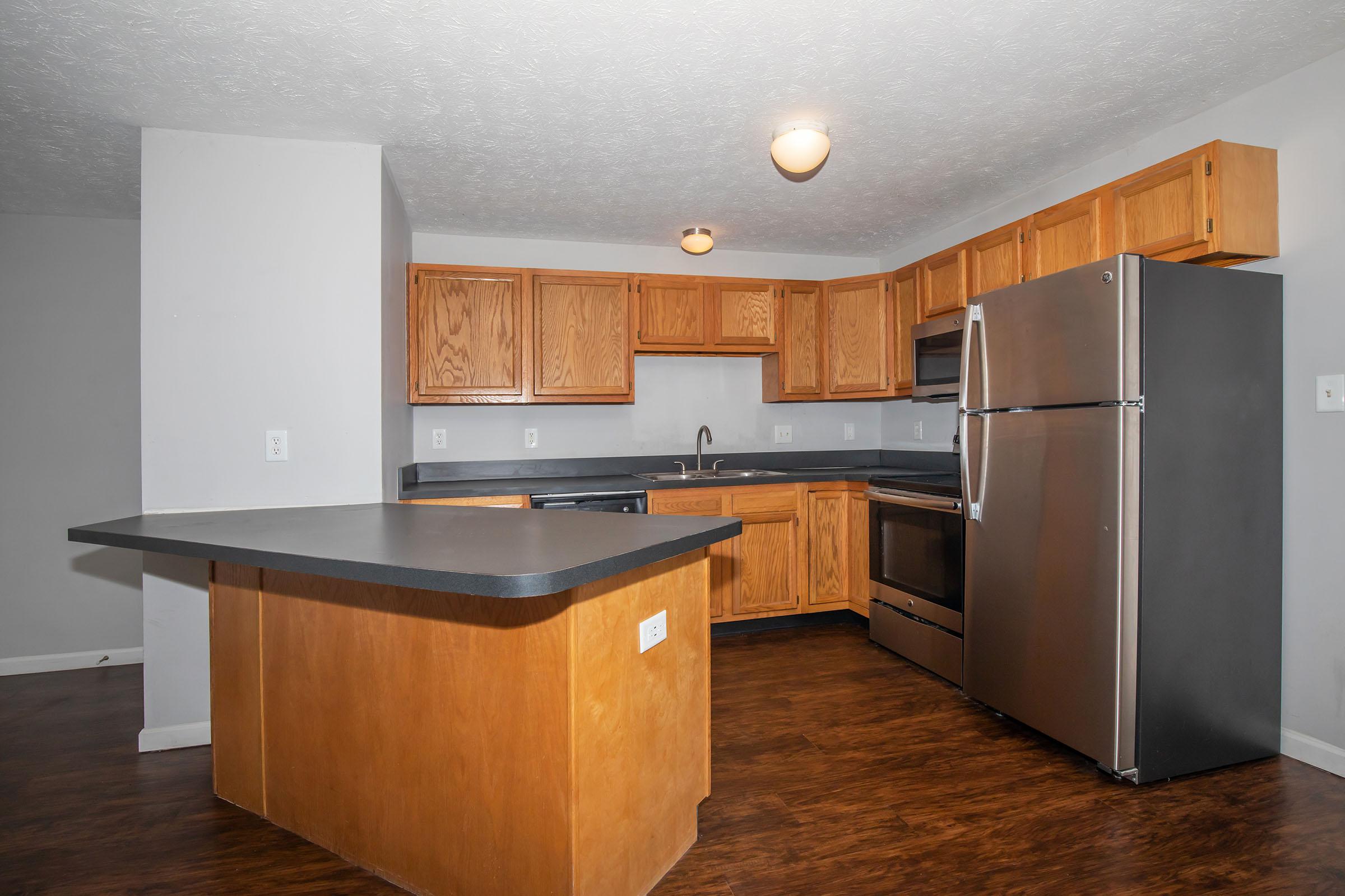 a large kitchen with stainless steel appliances and wooden cabinets