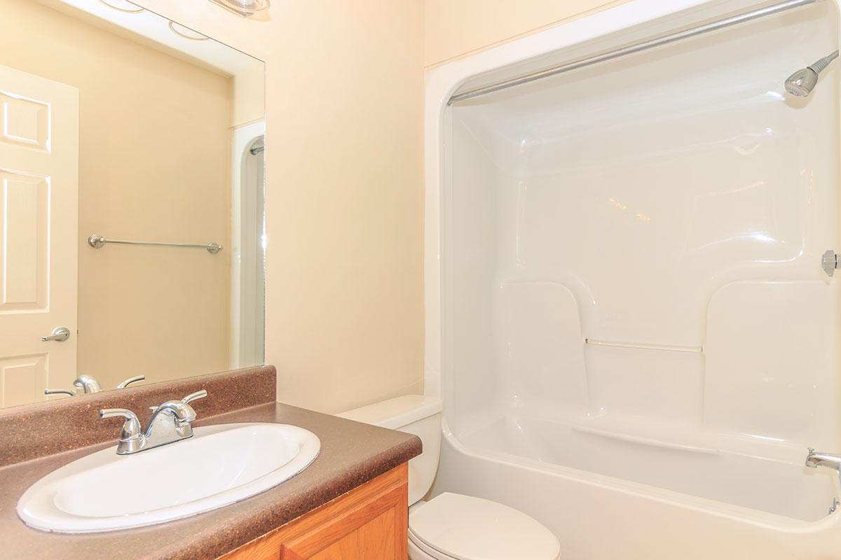 a white sink sitting under a mirror