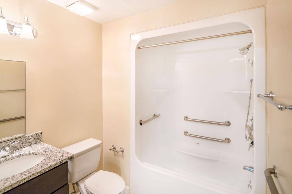 a white tub sitting next to a shower