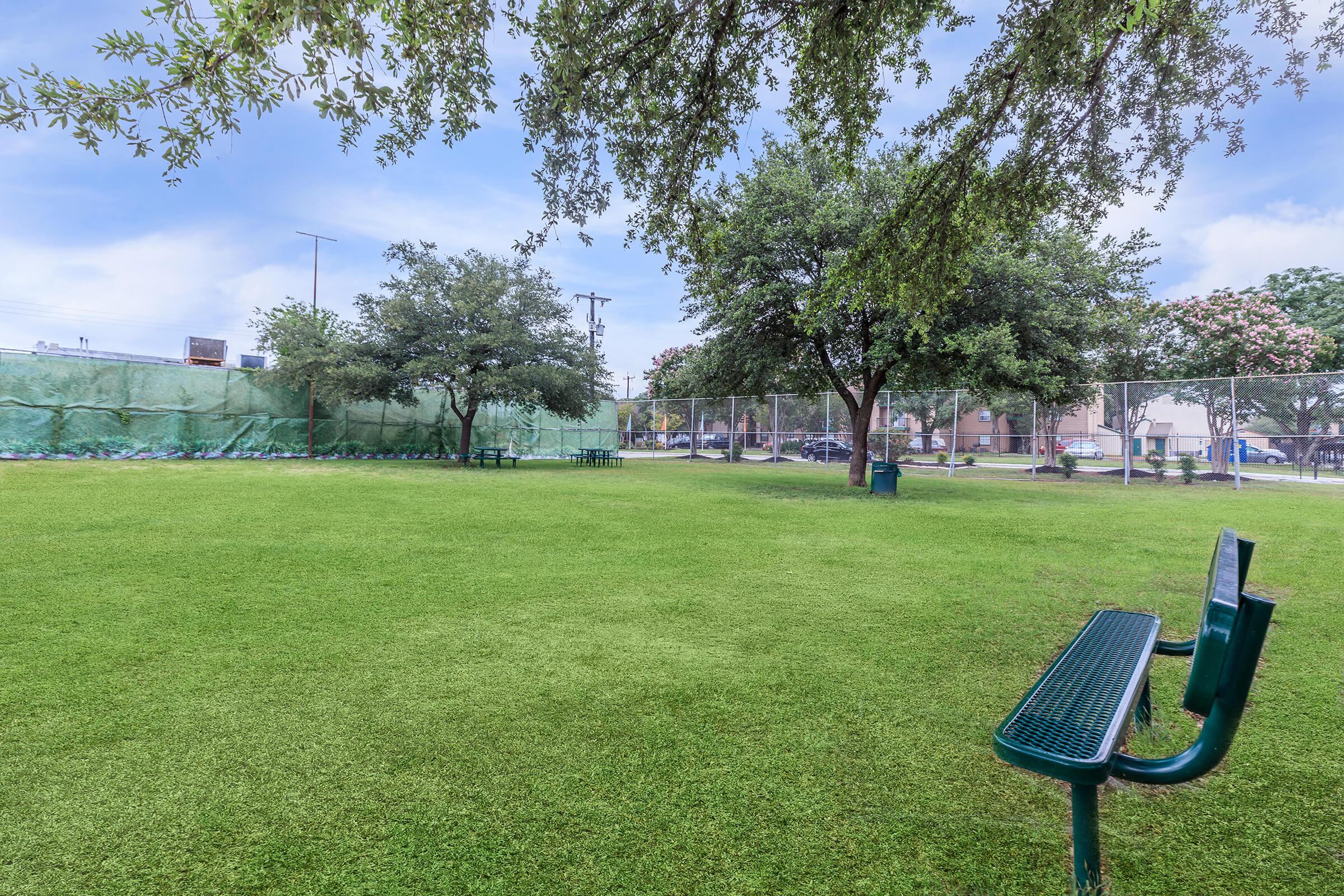 a couple of lawn chairs sitting on top of a grass covered field