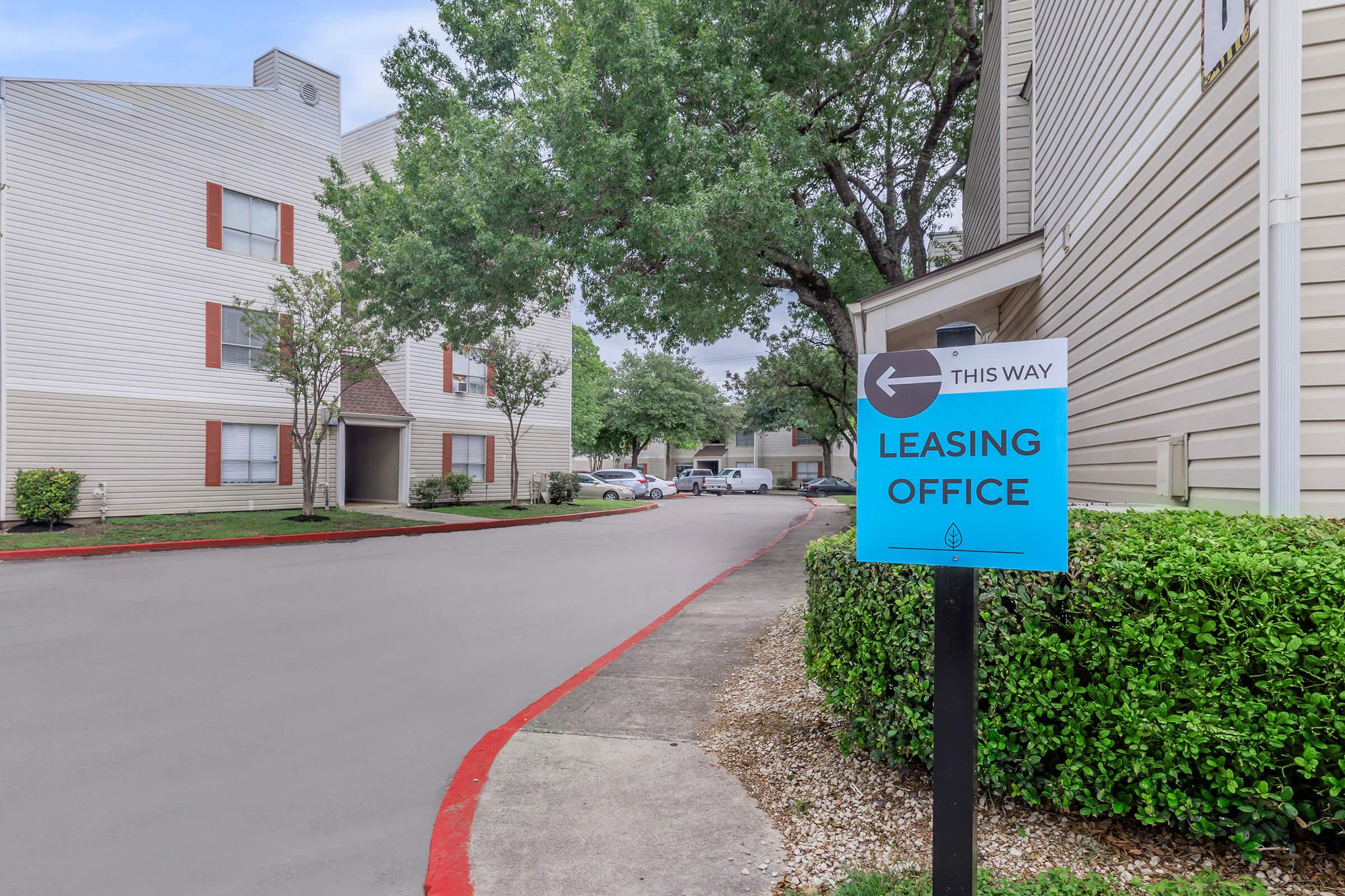 a house that has a sign on the side of a road