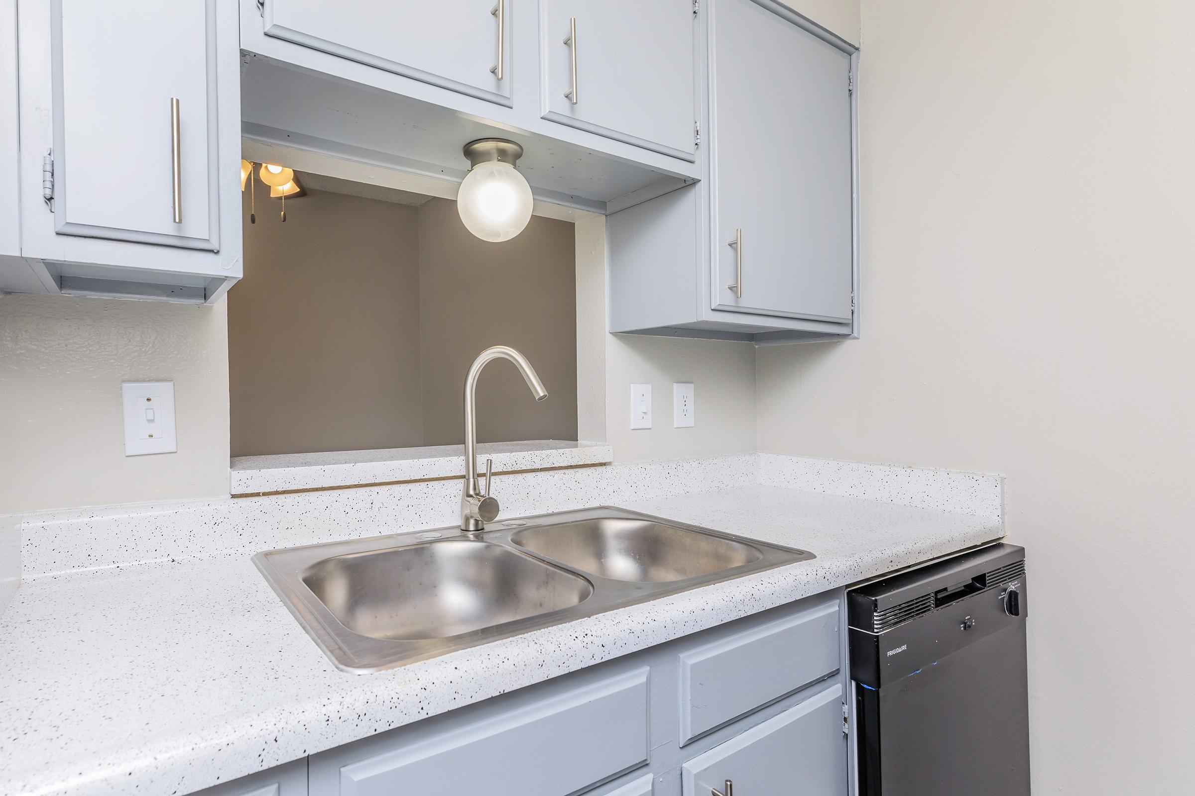 a kitchen with a sink and a mirror