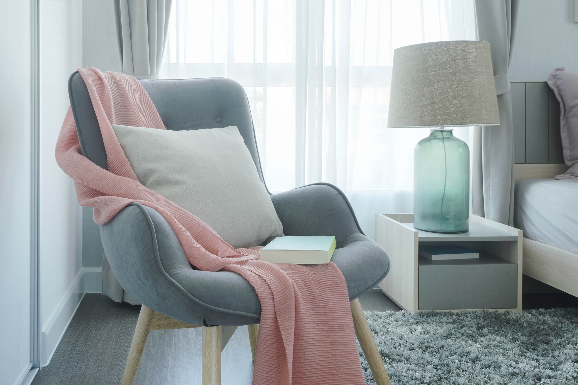 a living room with a bed and a chair