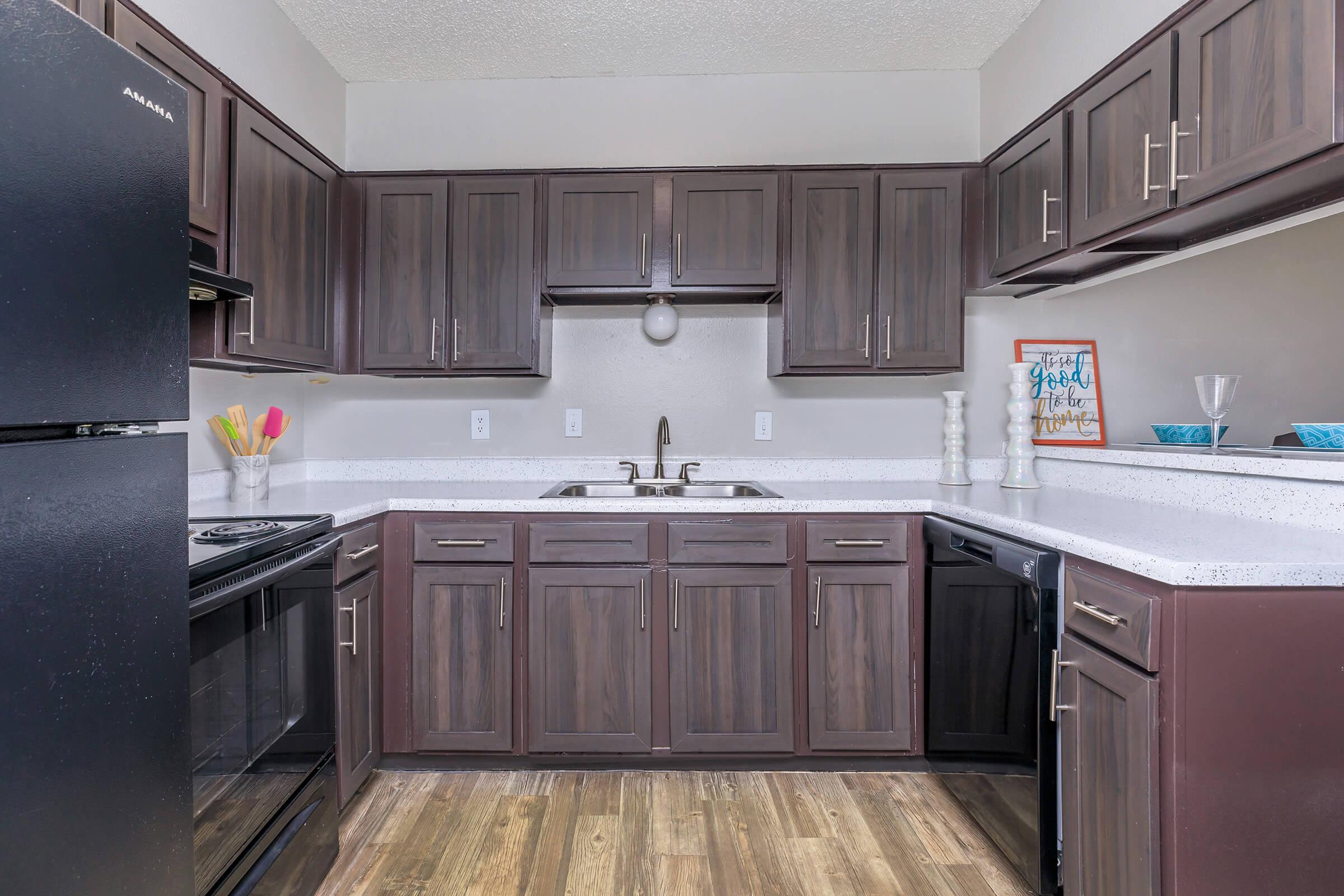 a large kitchen with stainless steel appliances and wooden cabinets