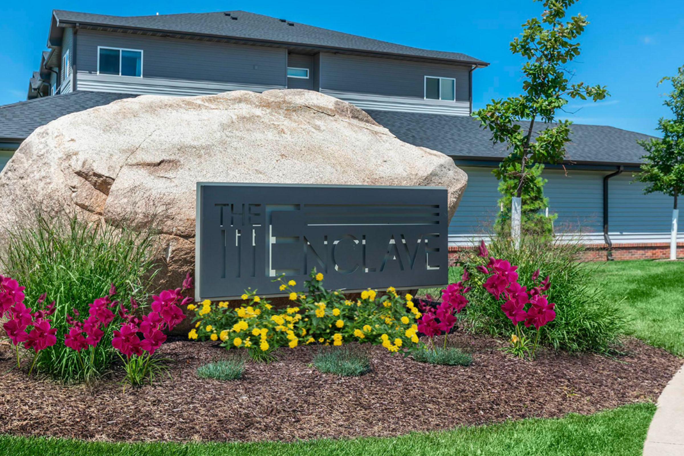 a close up of a flower garden in front of a house