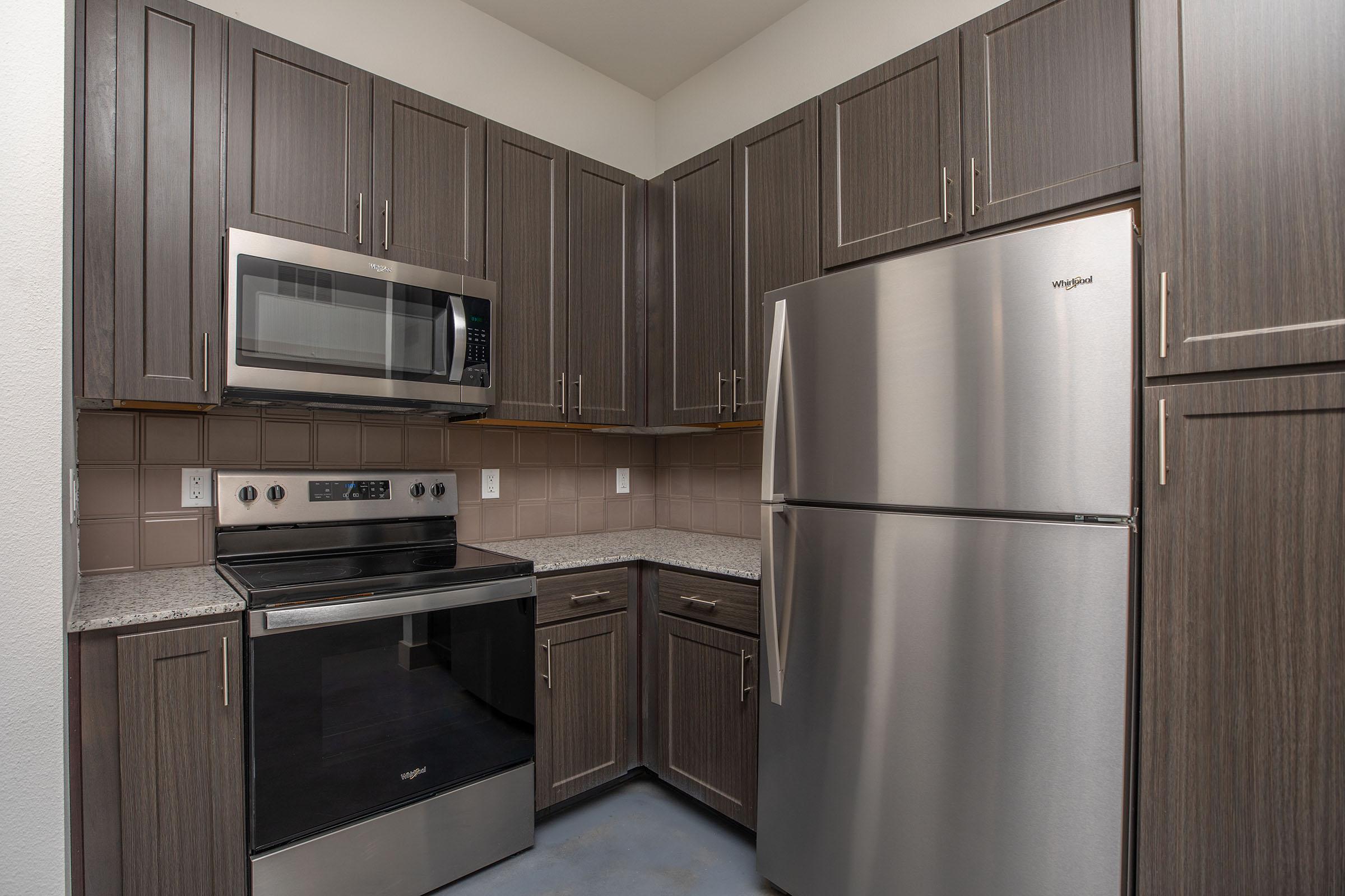 a kitchen with stainless steel appliances and wooden cabinets