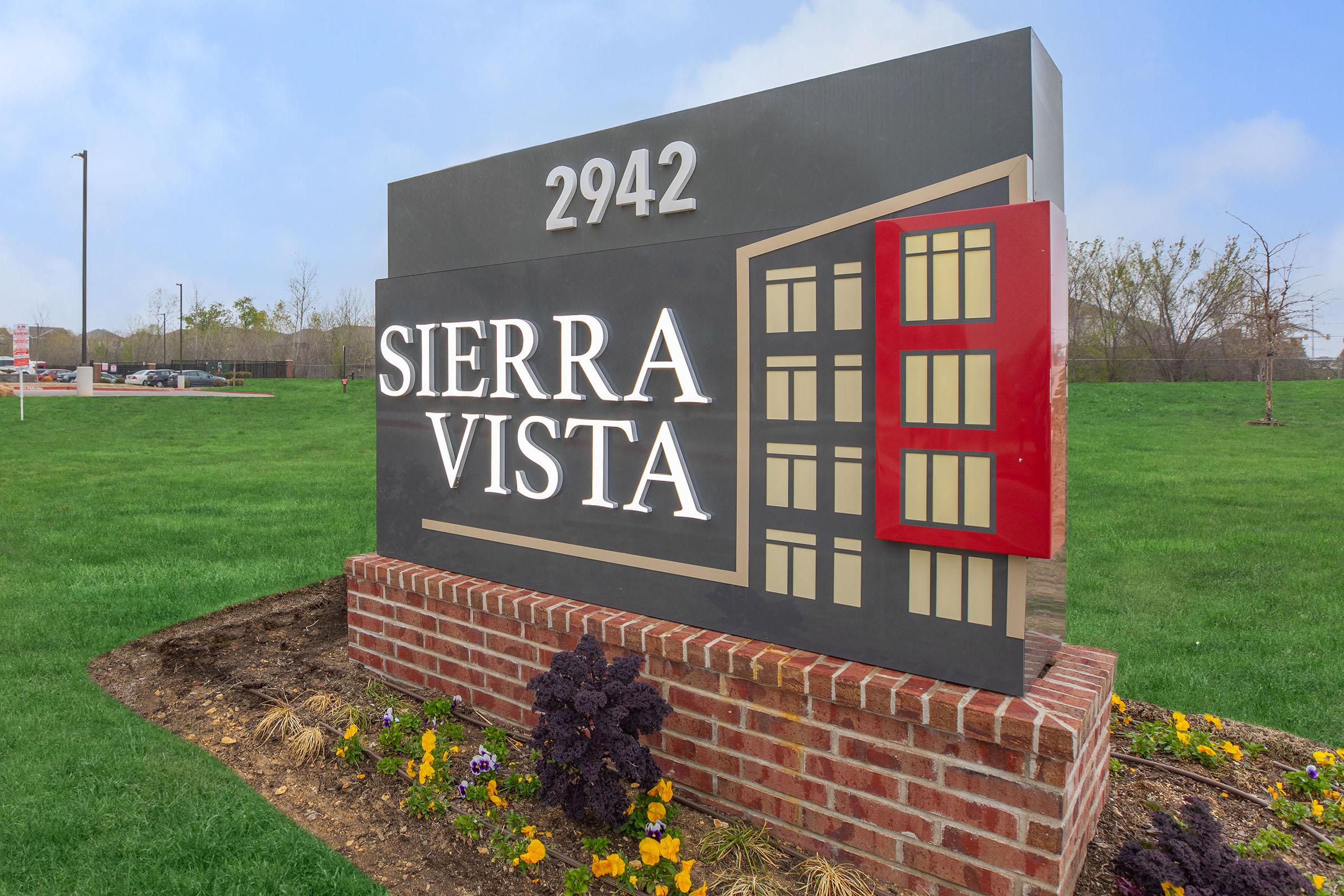 a sign sitting on top of a grass covered field