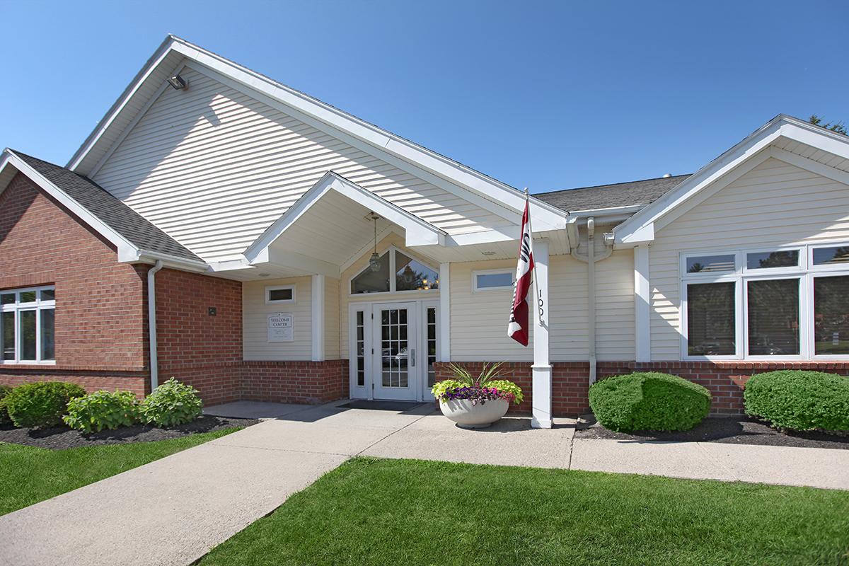 a house with a lawn in front of a brick building