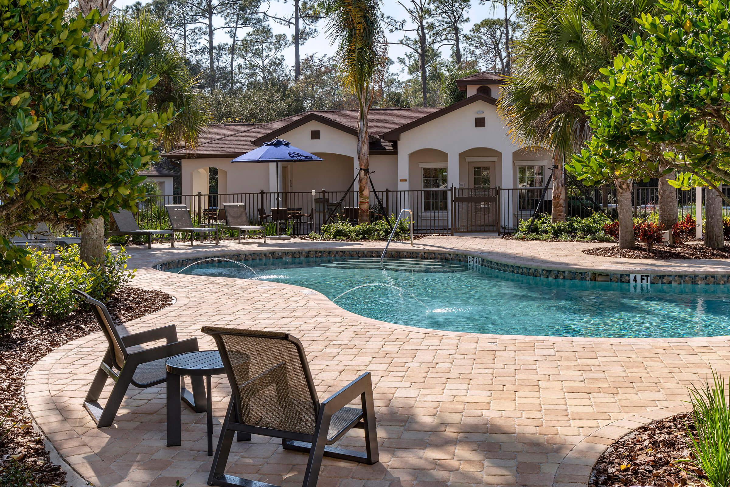 a couple of lawn chairs sitting next to a pool of water